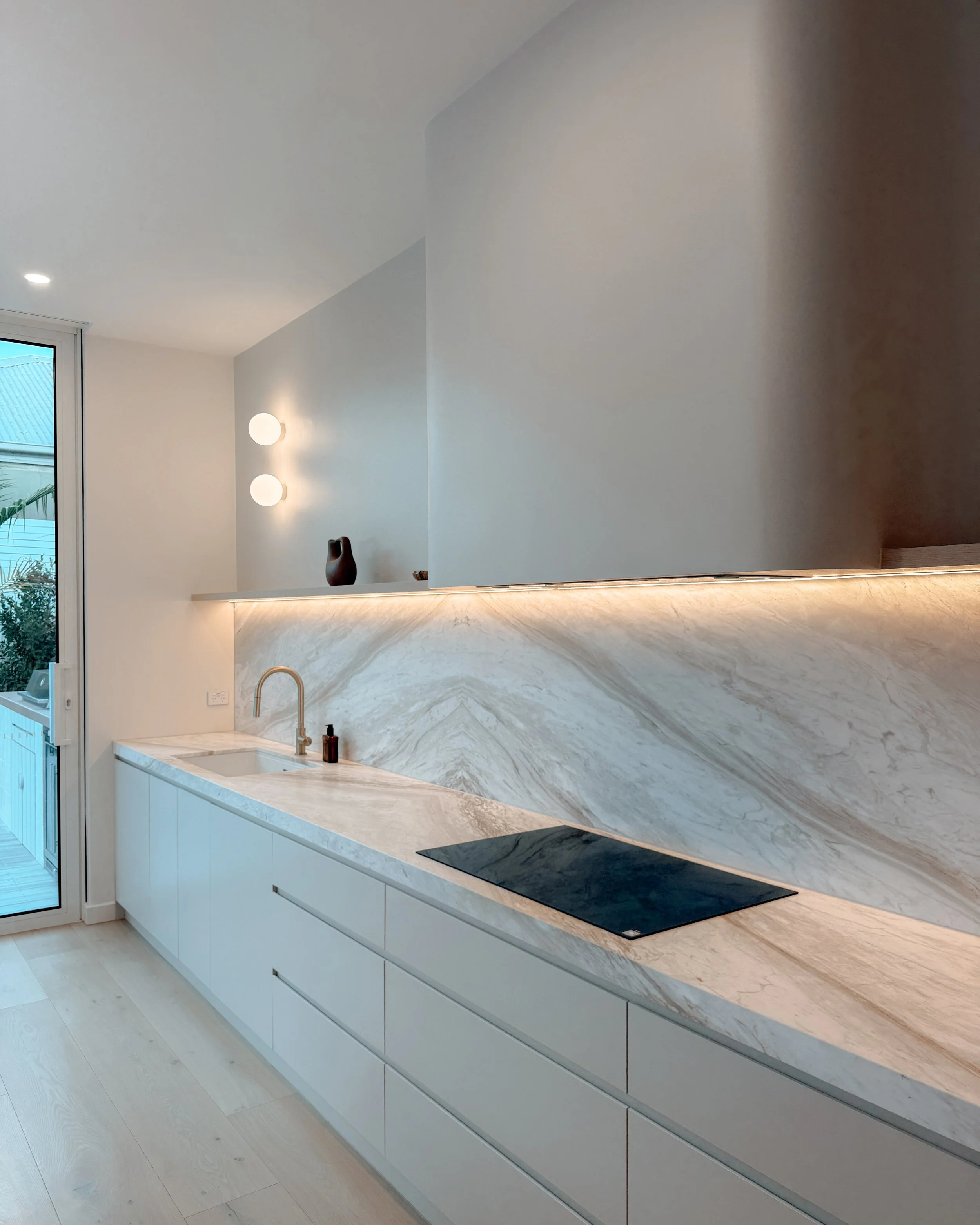 Contemporary soft-curved kitchen with fluted island, light timber cabinetry, and sculptural rangehood in a minimal-luxe Melbourne new-build. Designed by TID Studio, interior design in Sydney