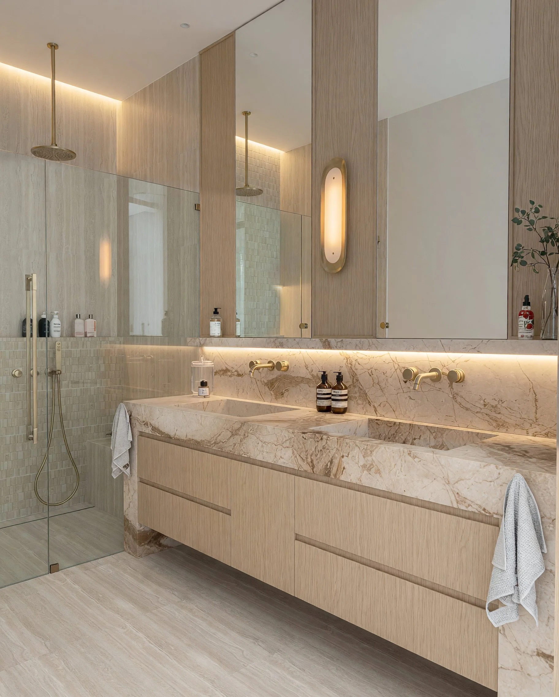 Modern master ensuite with double vanity, double shower, freestanding bathtub, bronze fixtures and contemporary lighting, designed by TID Studio 