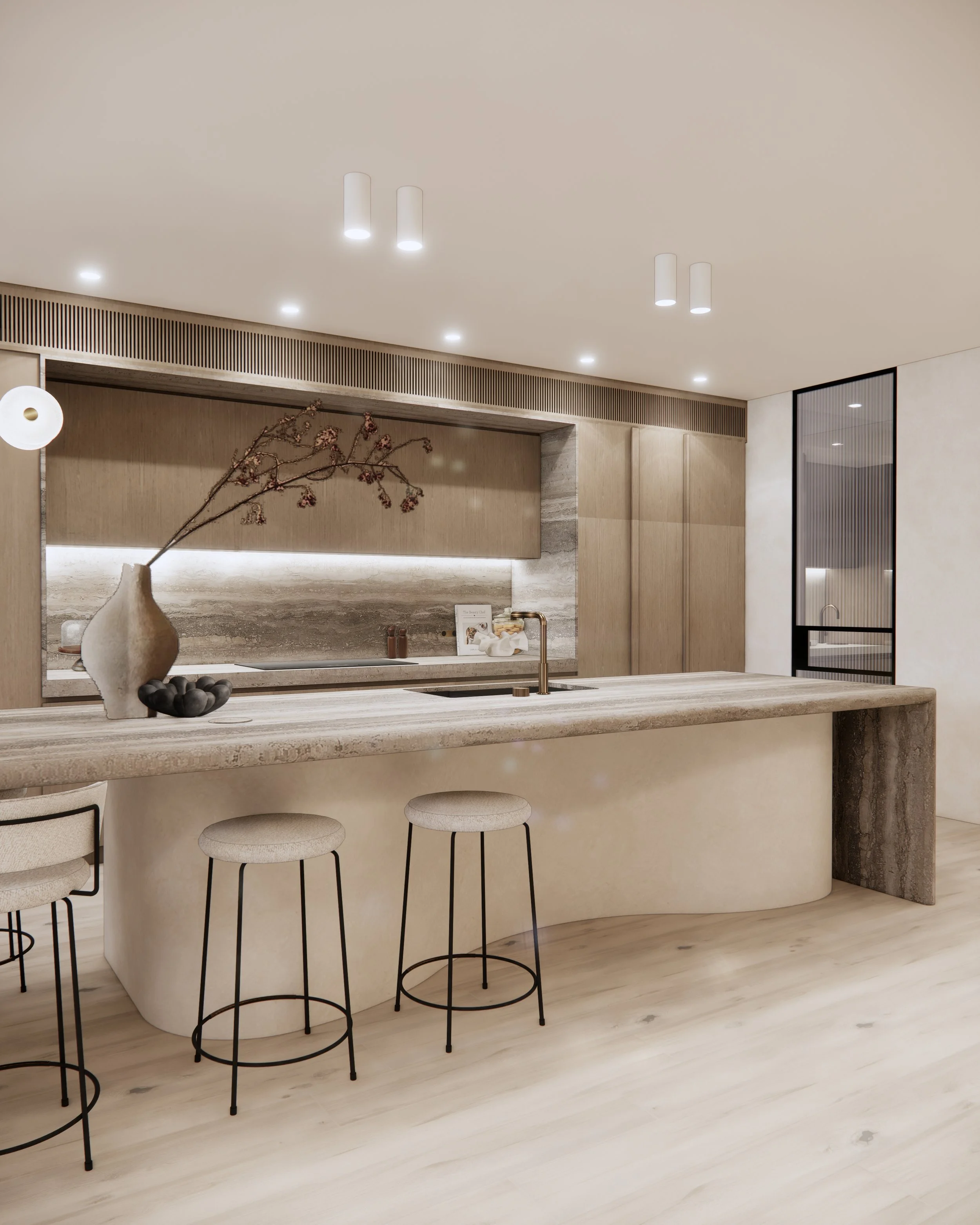 Open-plan kitchen with sculptural stone island, brass fixtures, and soft minimal design