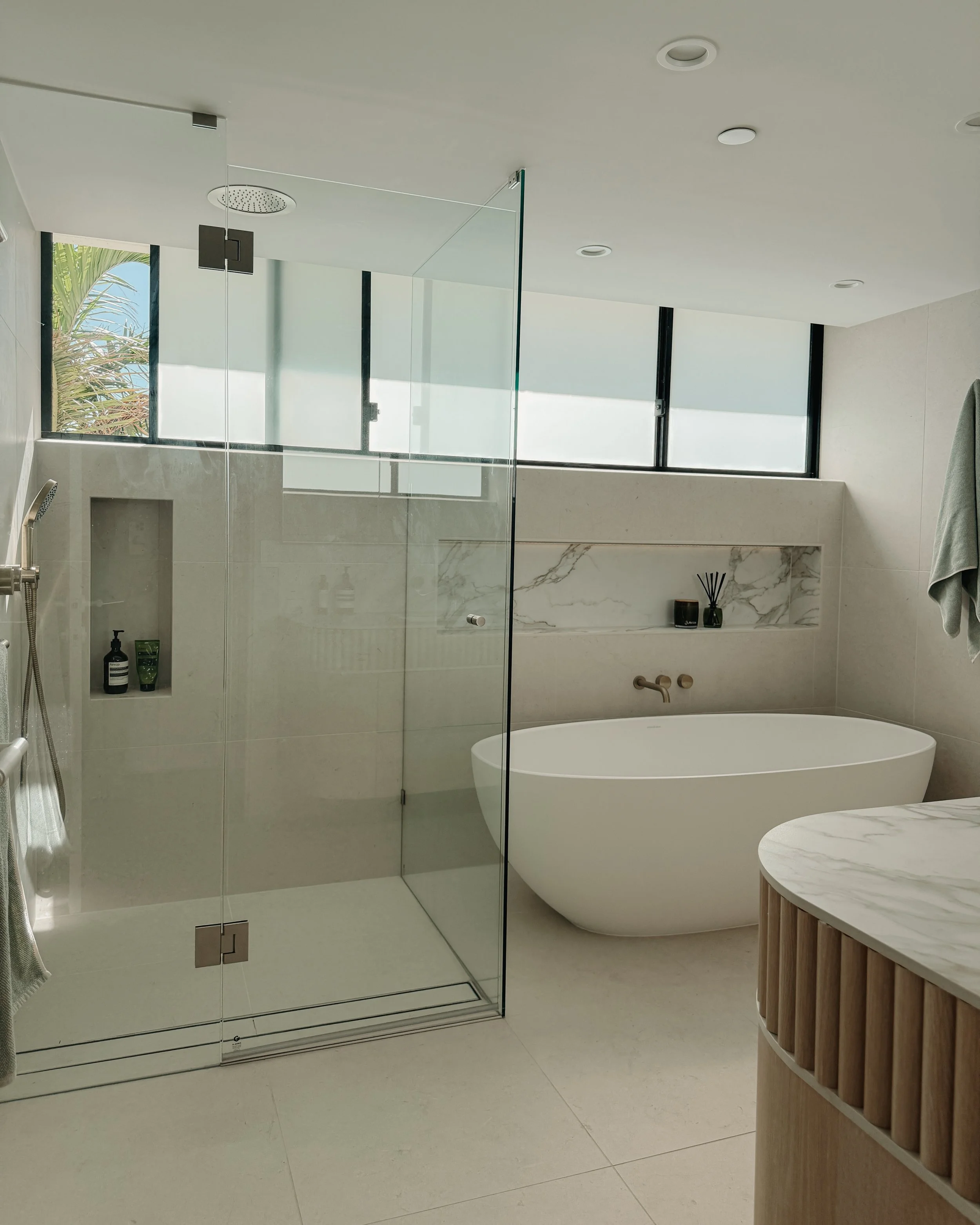Modern bathroom custom curved vanity, and warm timber tones, fluted timber detail — coastal apartment in Gold Coast designed by TID Studio Sydney