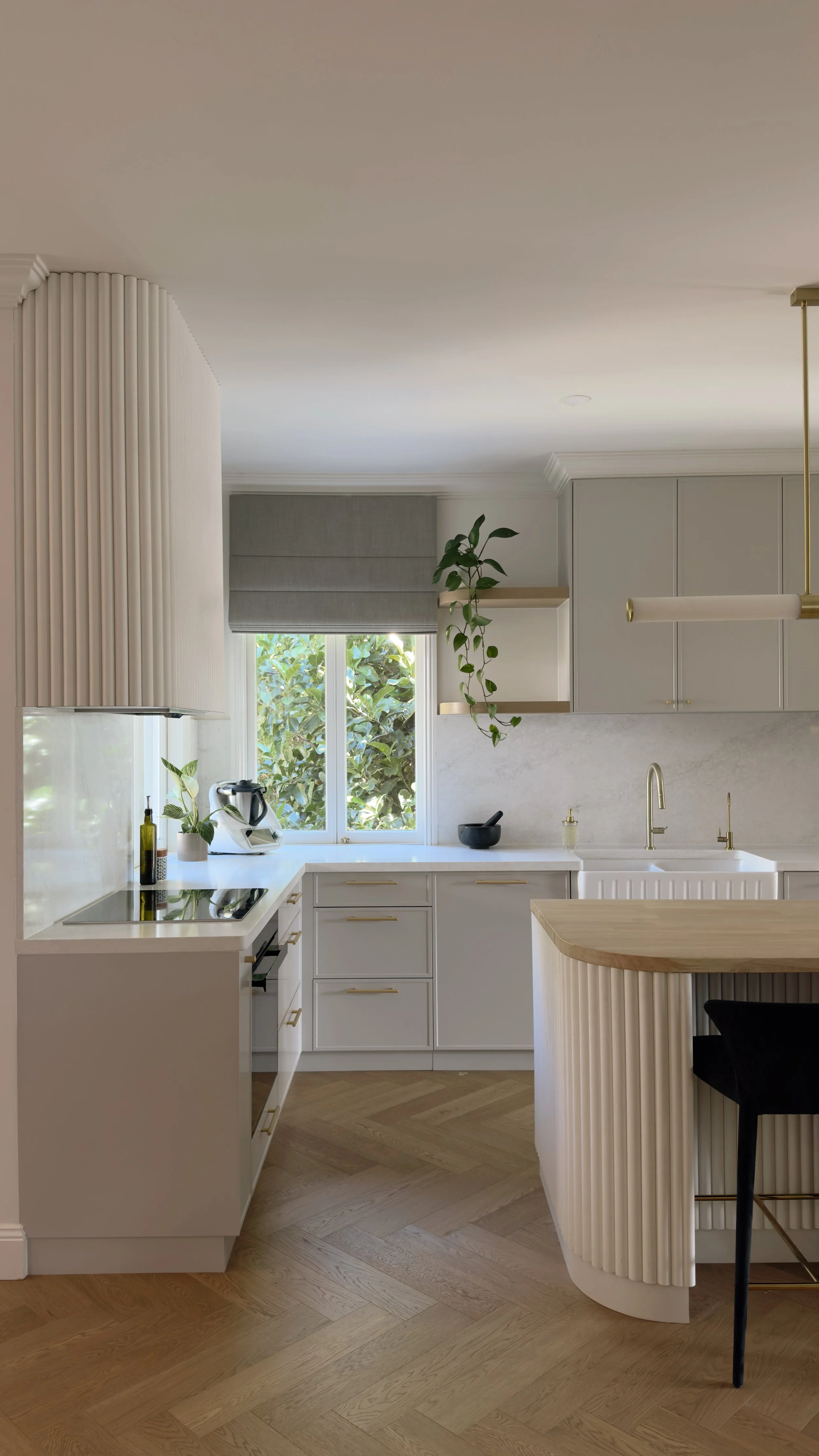 Modern Brisbane kitchen render showing curved island, warm timber tones and integrated appliances
