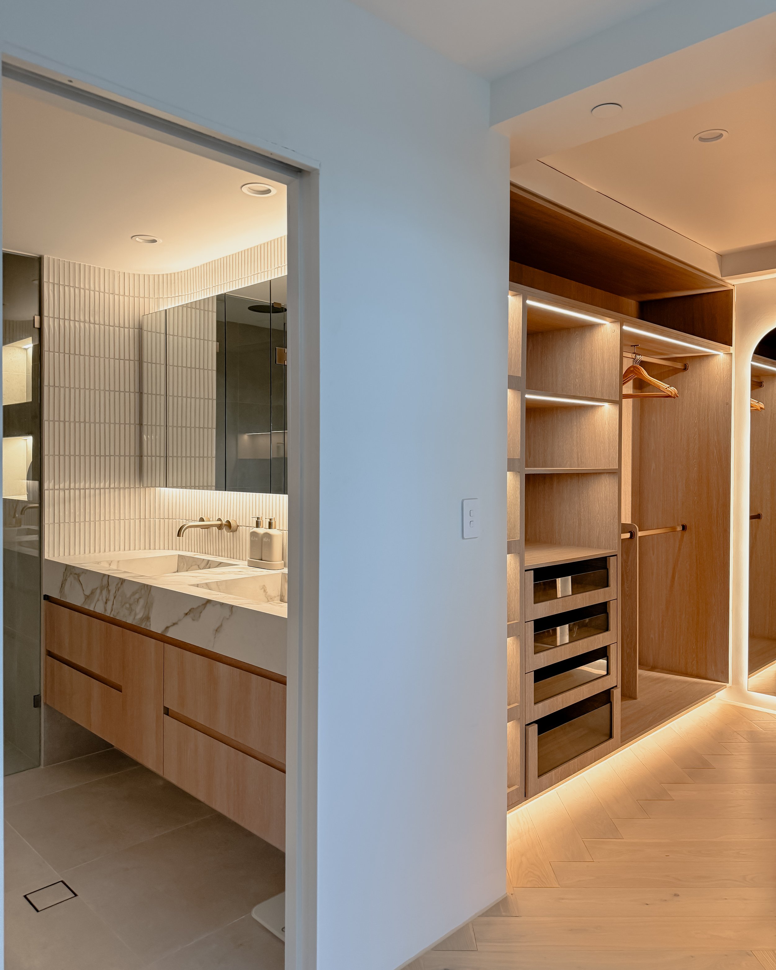Modern bathroom with stone sink, double vanity, and warm timber tones, WiR, Walk in Robe, closet — coastal apartment in Gold Coast designed by TID Studio Sydney