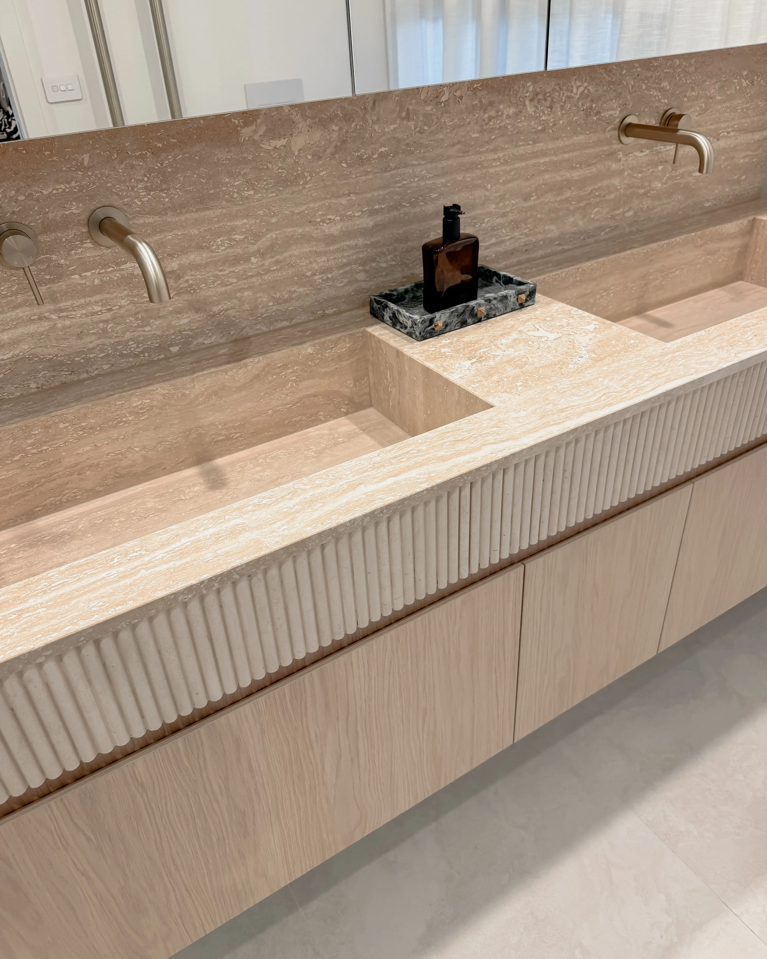 Contemporary Master Ensuite with custom stone sink, fluted travertine, double vanity, double shower in Melbourne new-build. Designed by TID Studio, interior design in Sydney