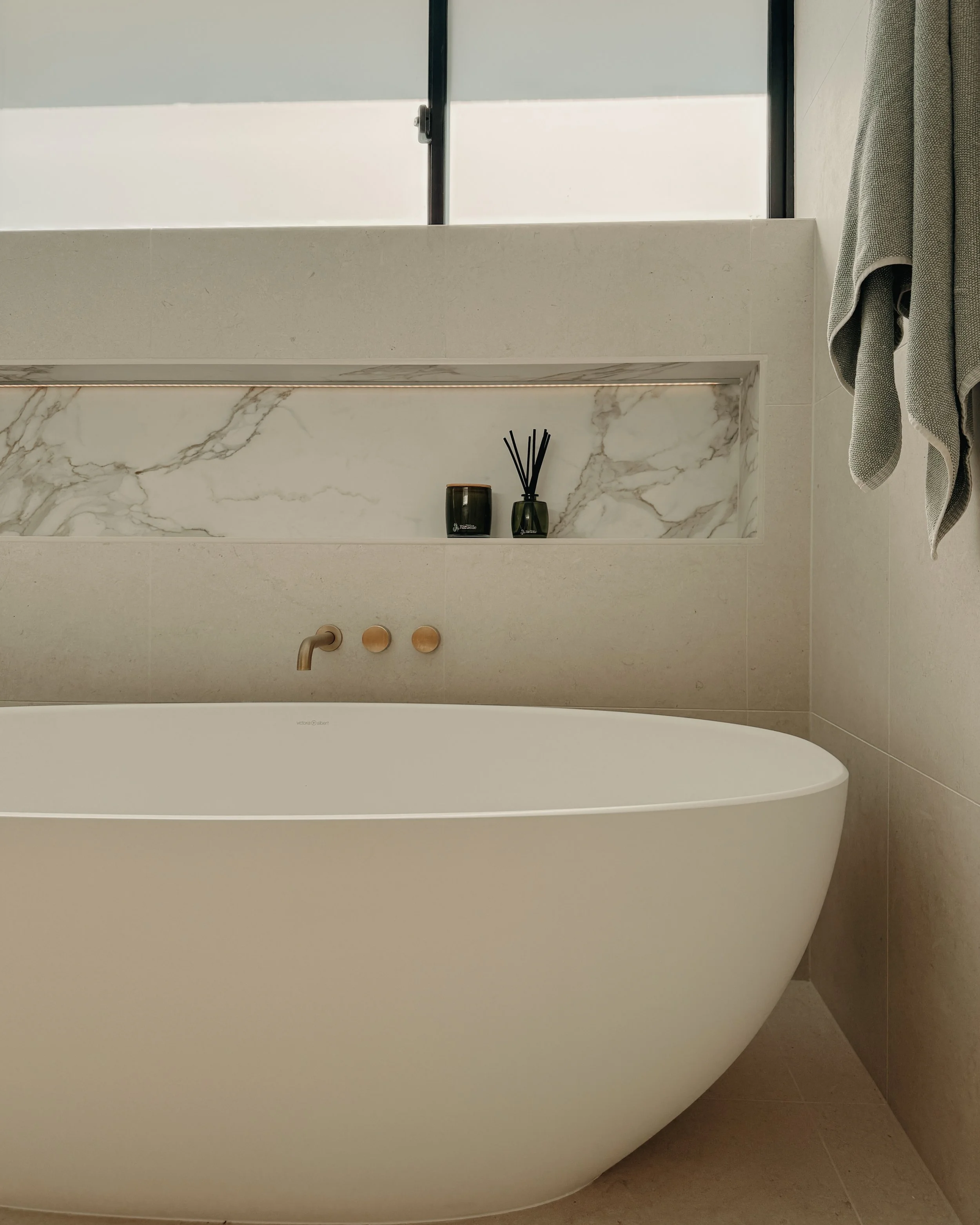 Modern bathroom custom curved vanity, and warm timber tones, fluted timber detail — coastal apartment in Gold Coast designed by TID Studio Sydney