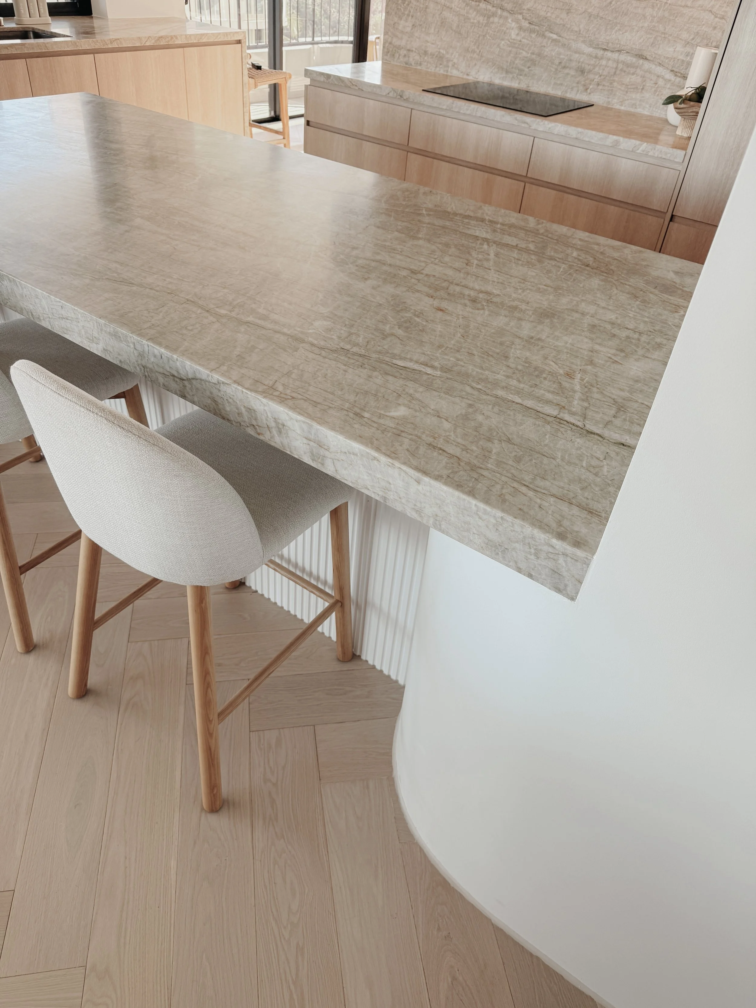 Soft neutral kitchen with ocean views and minimalist joinery by TID Studio