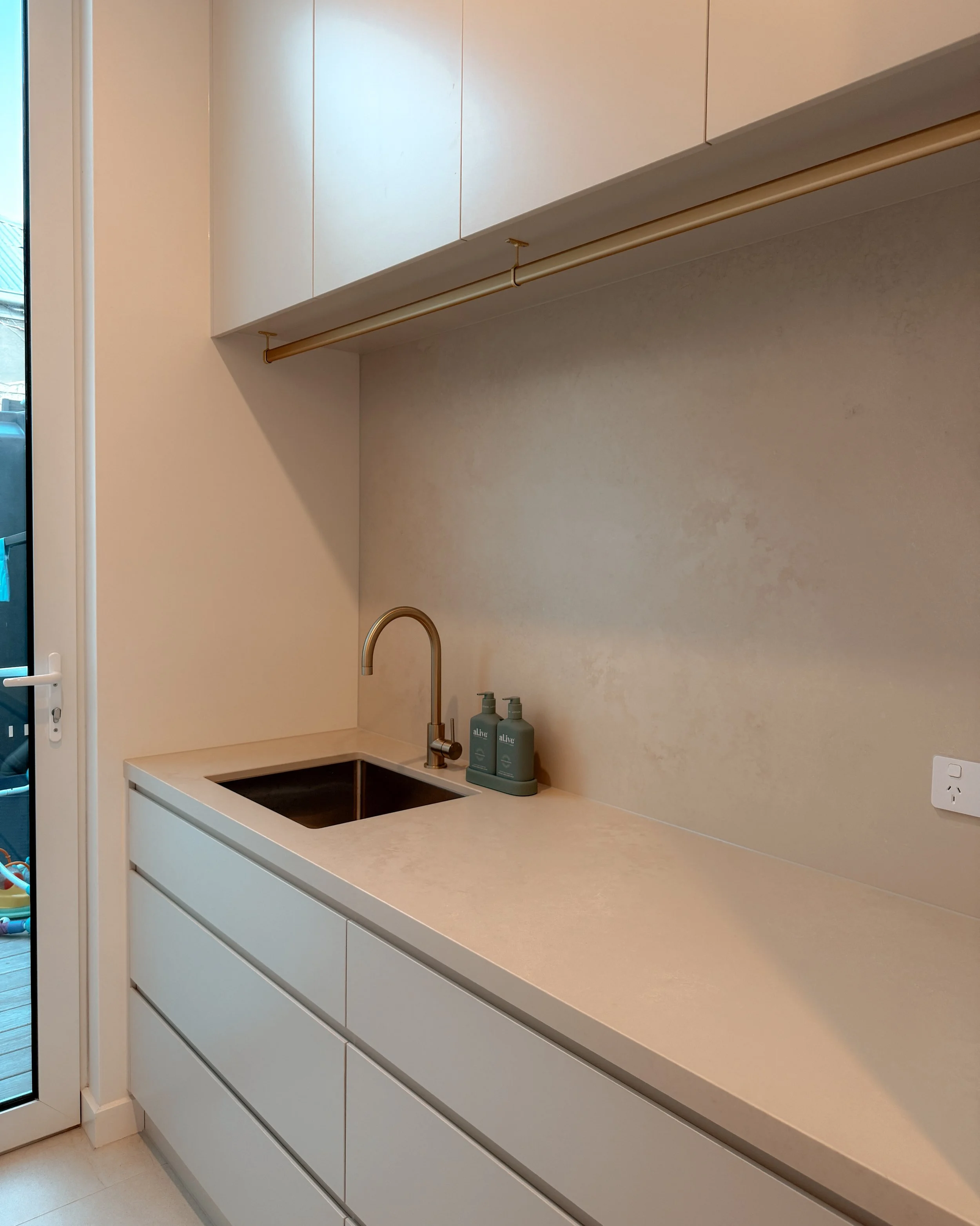 Contemporary soft-curved kitchen with fluted island, light timber cabinetry, and sculptural rangehood in a minimal-luxe Melbourne new-build. Designed by TID Studio, interior design in Sydney