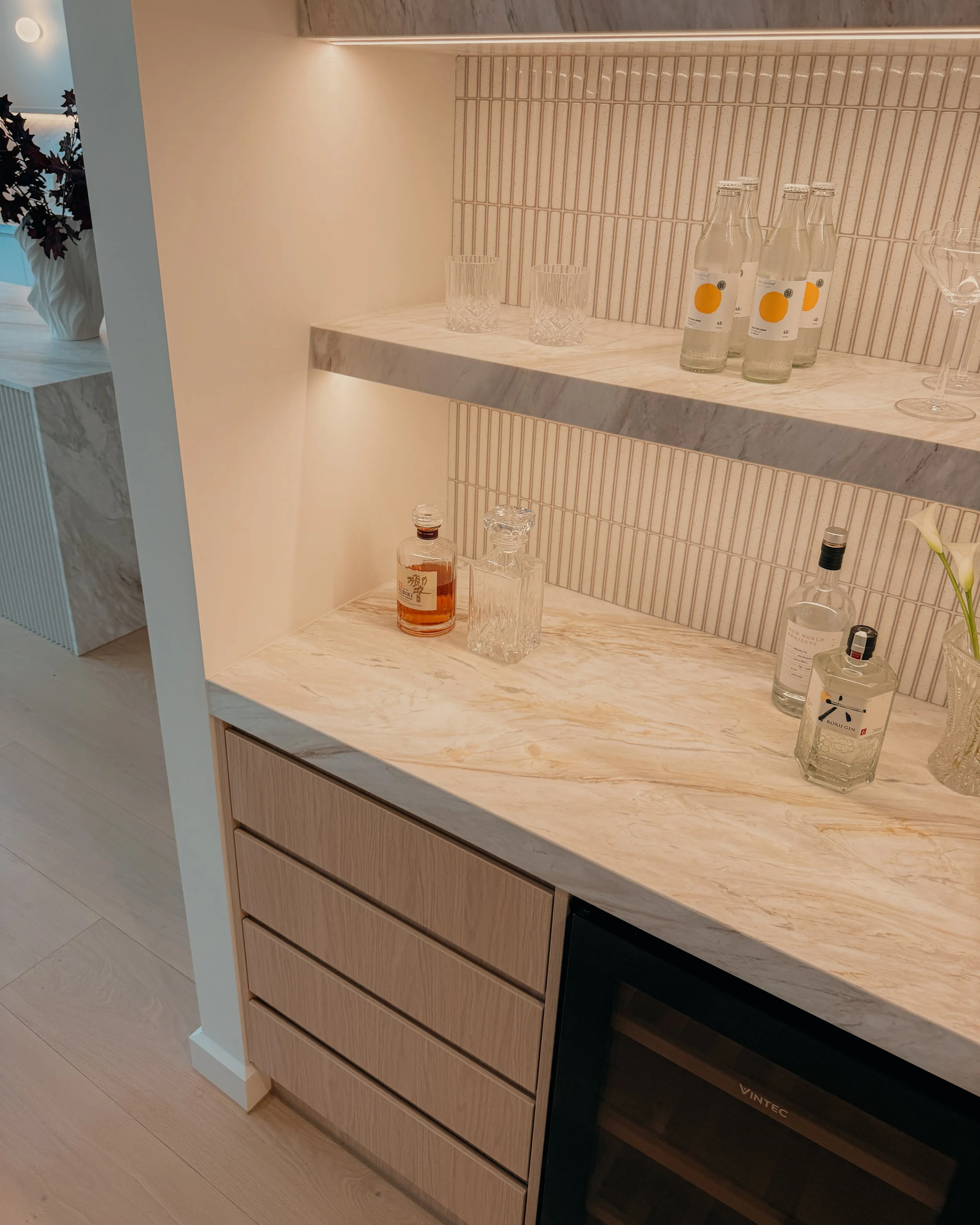Contemporary soft-curved kitchen with fluted island, light timber cabinetry, and sculptural rangehood in a minimal-luxe Melbourne new-build. Designed by TID Studio, interior design in Sydney