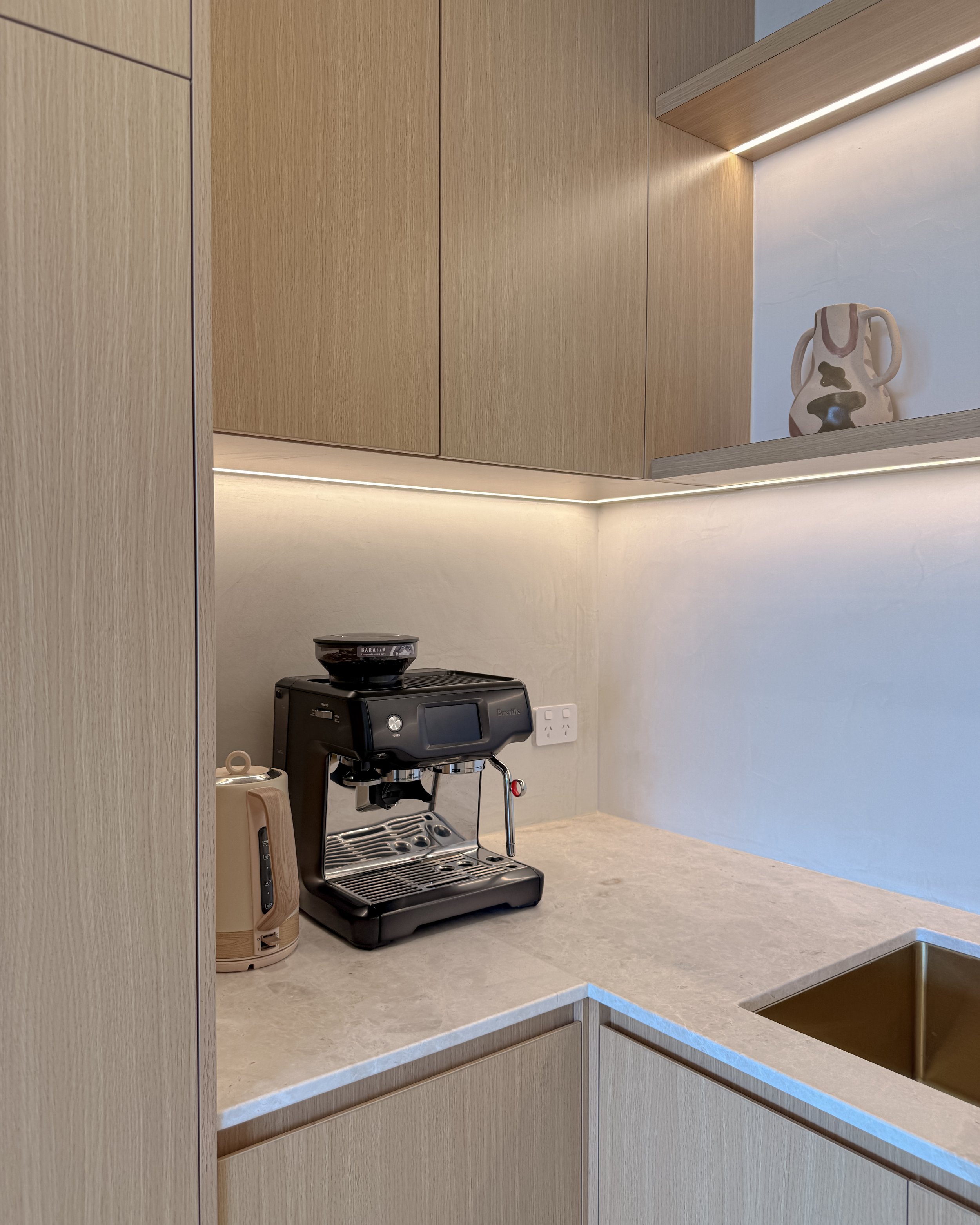 Modern coastal kitchen and pantry designed by TID Studio. Contemporary kitchen with curved cabinetry and fluted stone kitchen island. Sydney interior designer