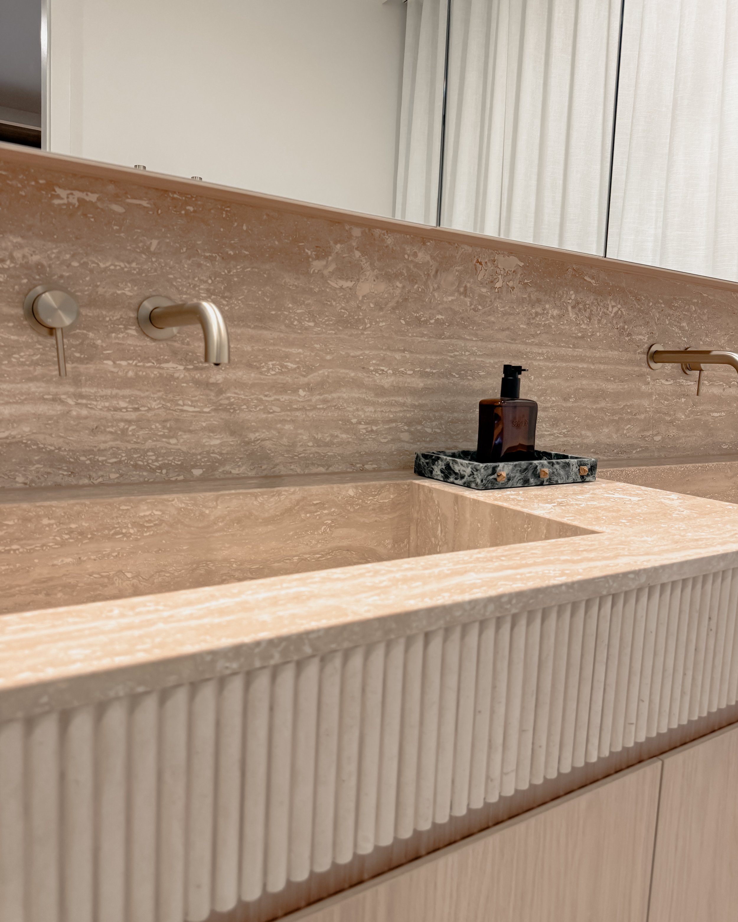 Contemporary Master Ensuite with custom stone sink, fluted travertine, double vanity, double shower in Melbourne new-build. Designed by TID Studio, interior design in Sydney