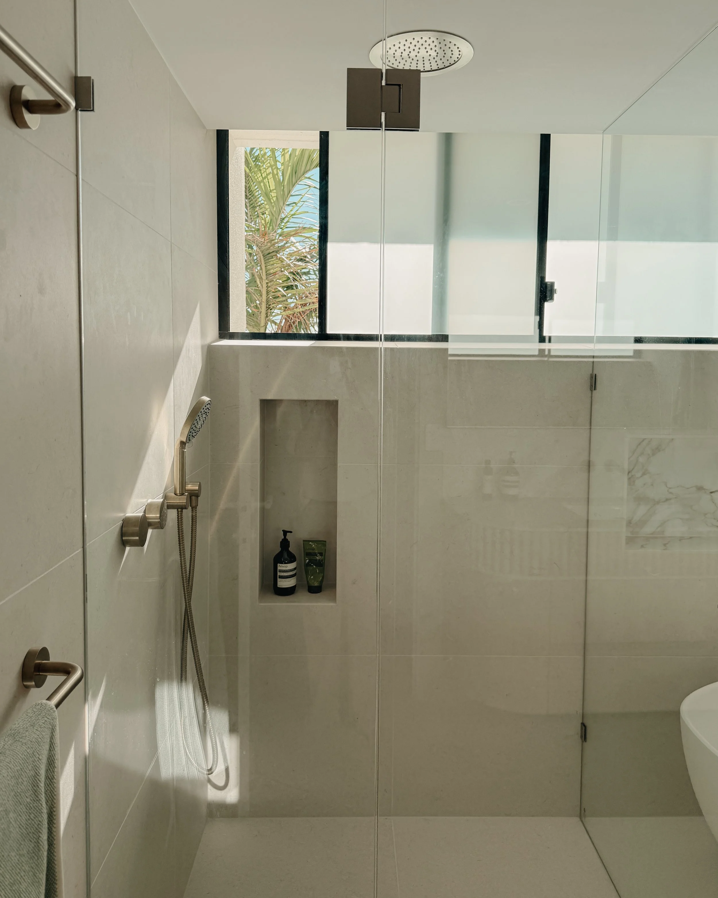 Modern bathroom custom curved vanity, and warm timber tones, fluted timber detail — coastal apartment in Gold Coast designed by TID Studio Sydney