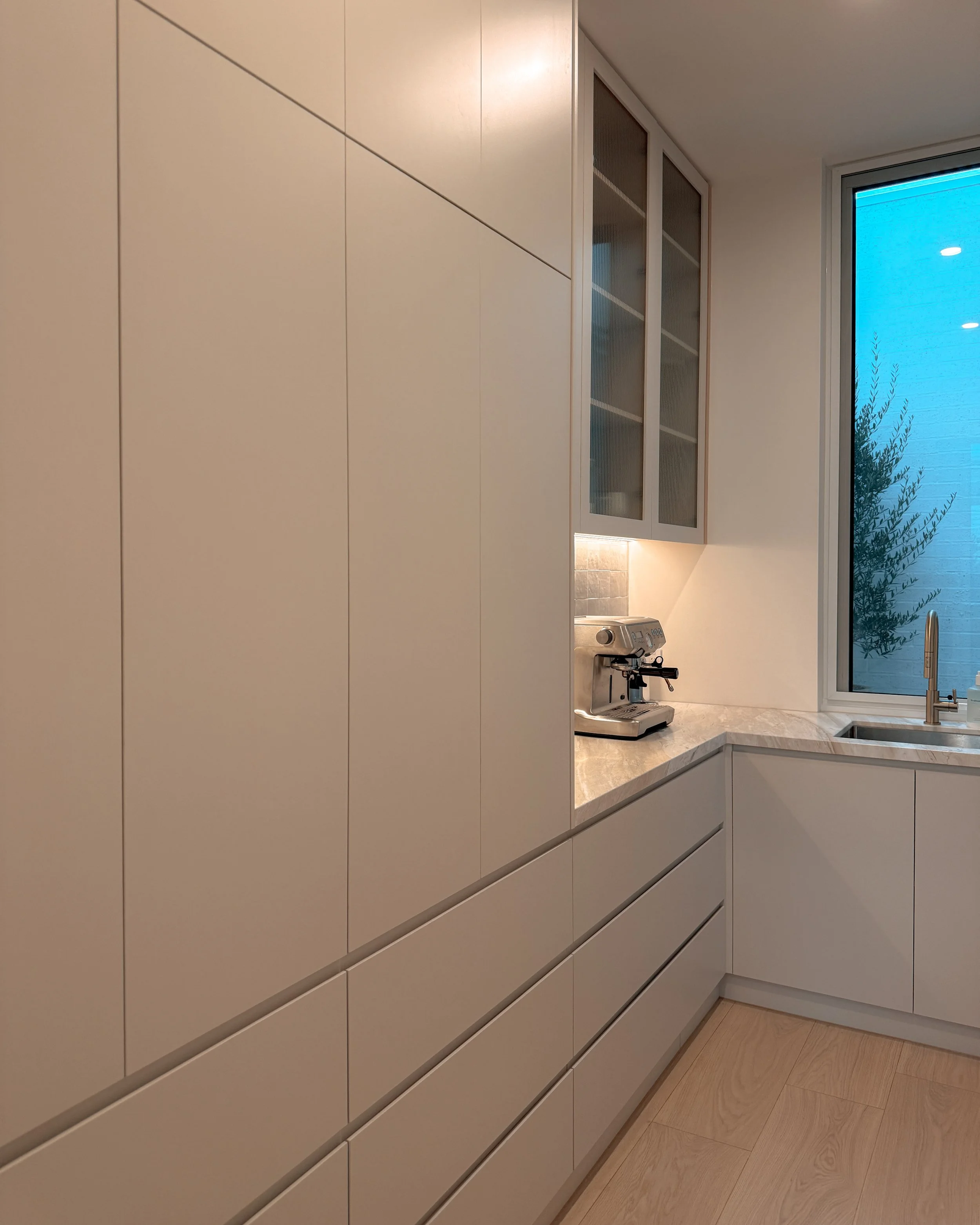 Contemporary soft-curved kitchen with fluted island, light timber cabinetry, and sculptural rangehood in a minimal-luxe Melbourne new-build. Designed by TID Studio, interior design in Sydney