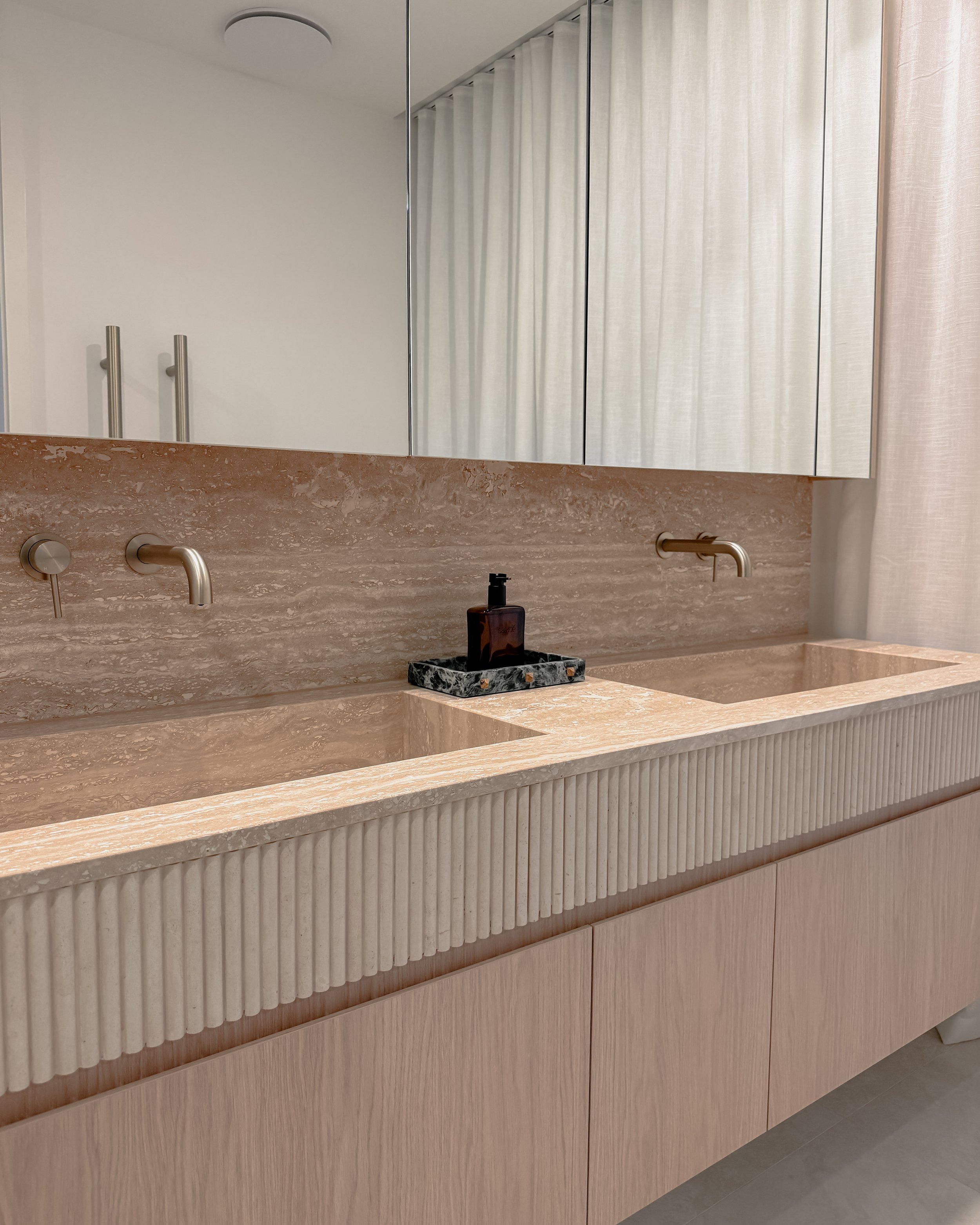 Contemporary Master Ensuite with custom stone sink, fluted travertine, double vanity, double shower in Melbourne new-build. Designed by TID Studio, interior design in Sydney