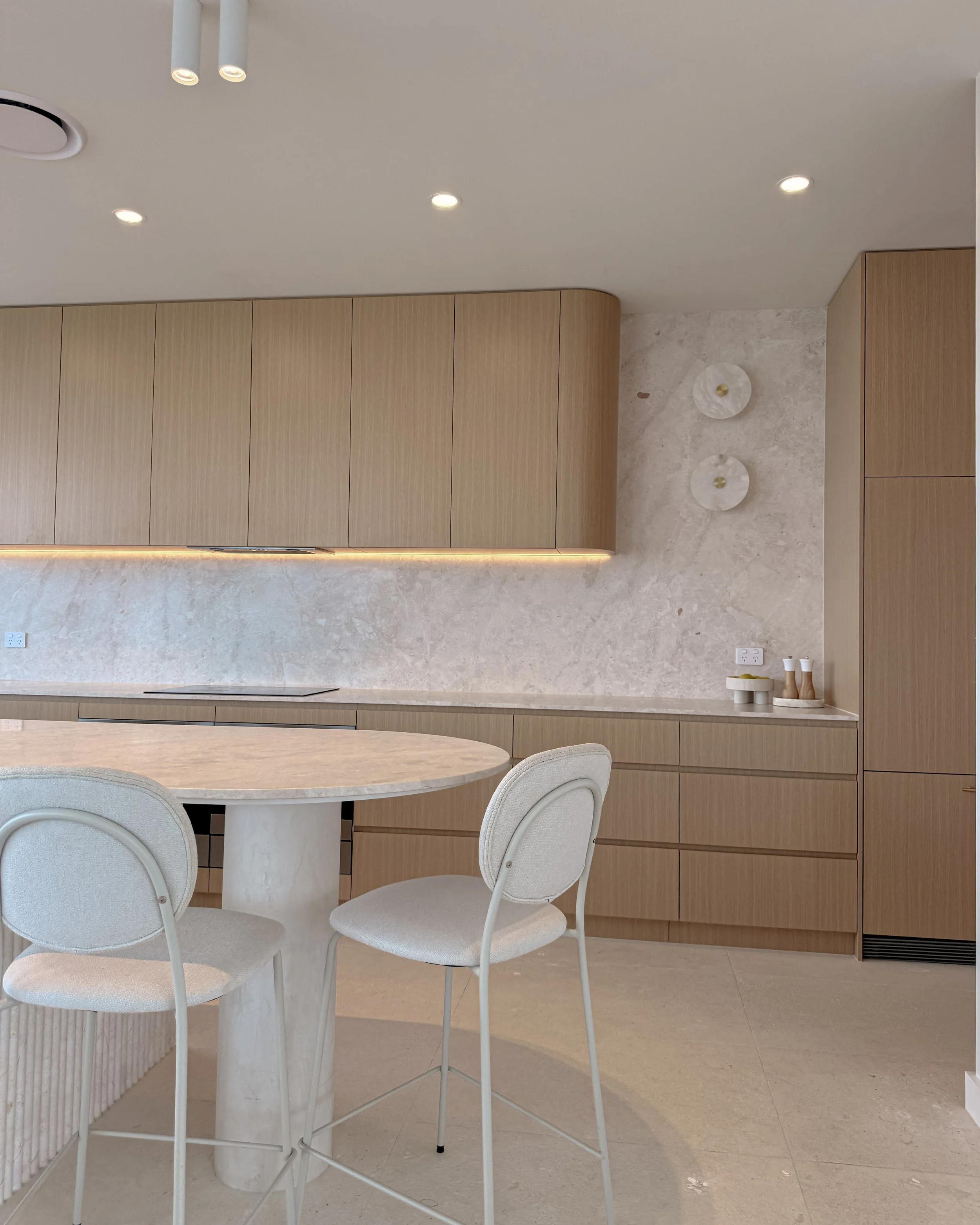 Modern coastal kitchen and pantry designed by TID Studio. Contemporary kitchen with curved cabinetry and fluted stone kitchen island. Sydney interior designer