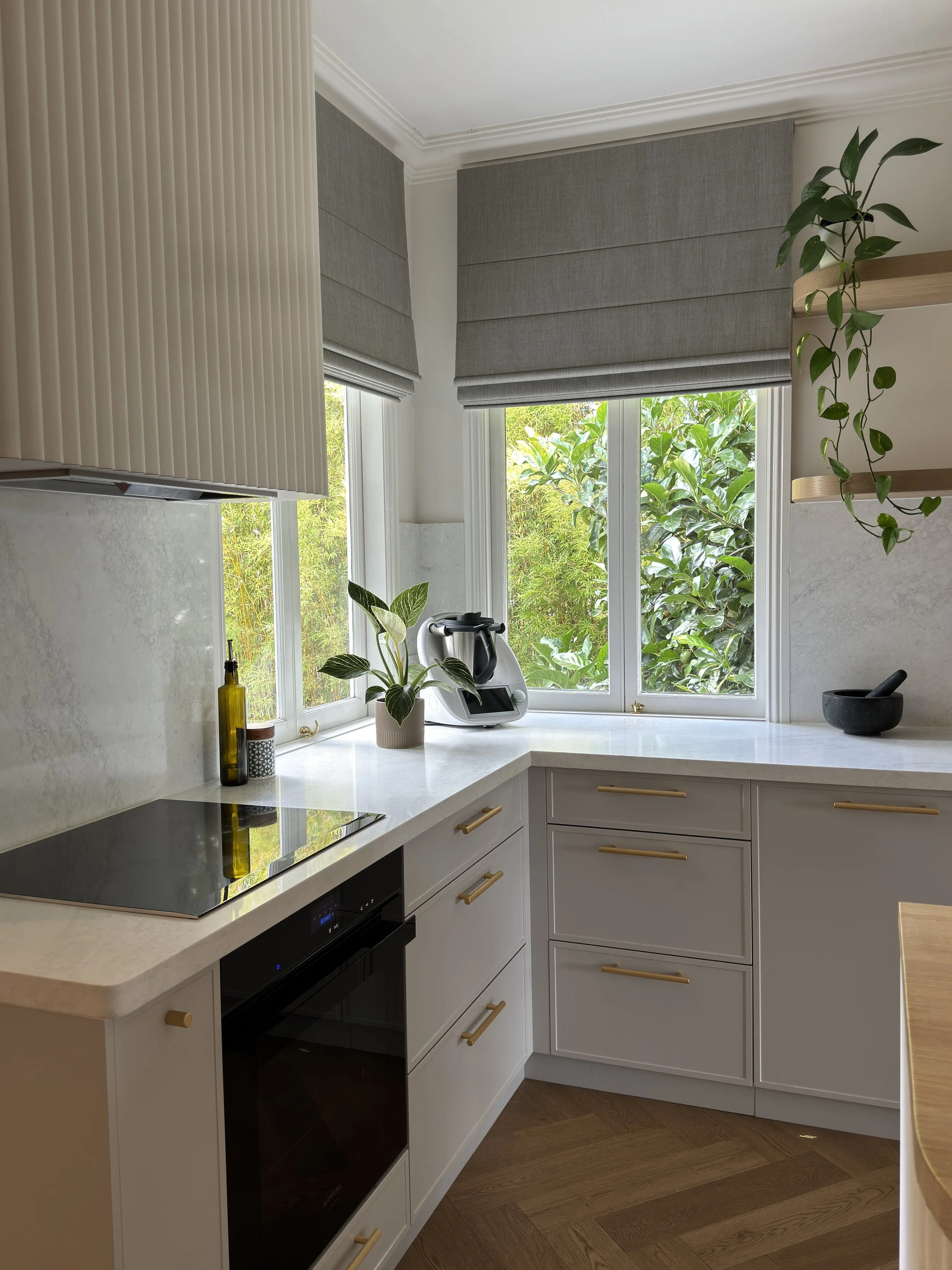 Modern Brisbane kitchen render showing curved island, warm timber tones and integrated appliances