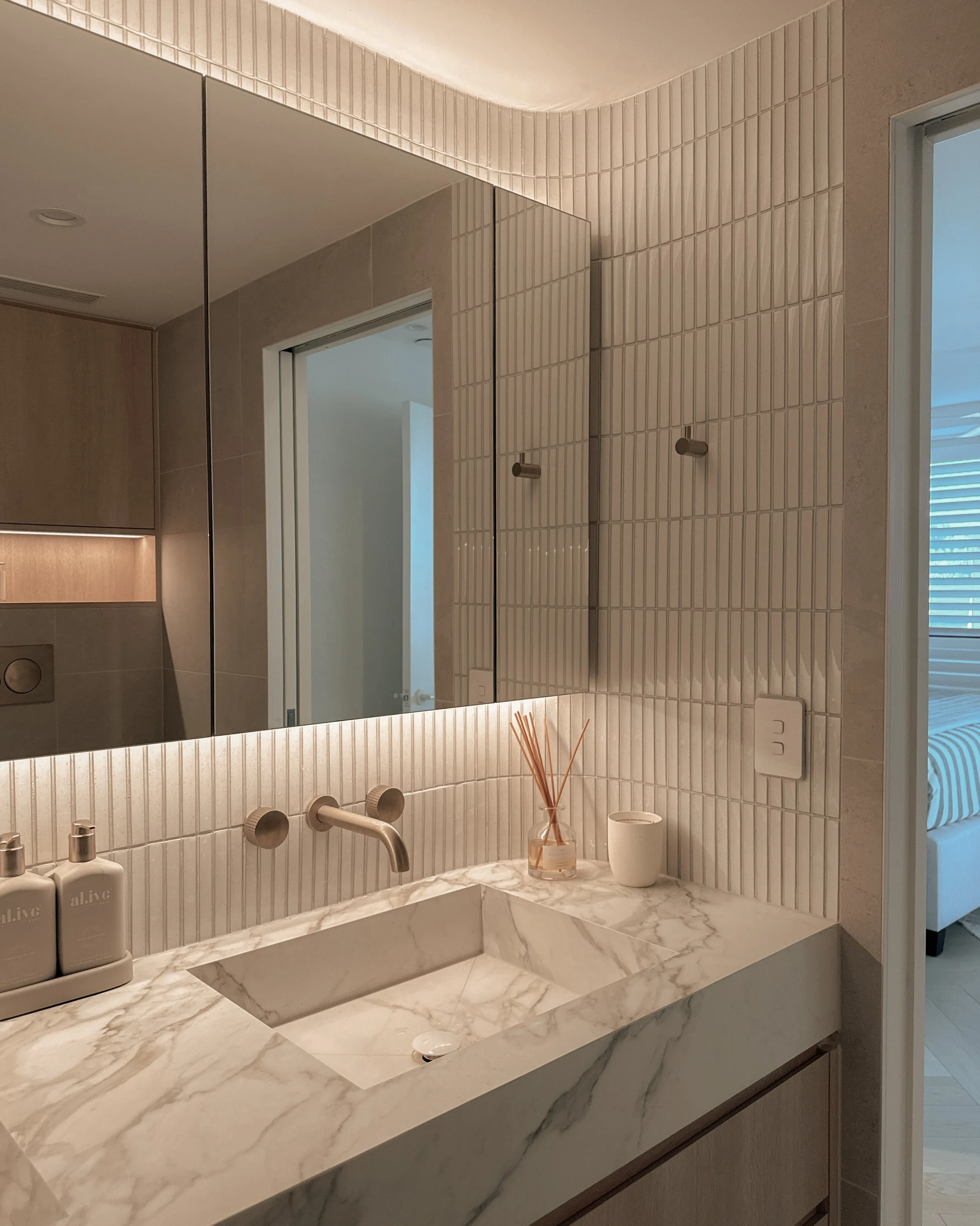 Modern bathroom with stone sink, double vanity, and warm timber tones — coastal apartment in Gold Coast designed by TID Studio Sydney