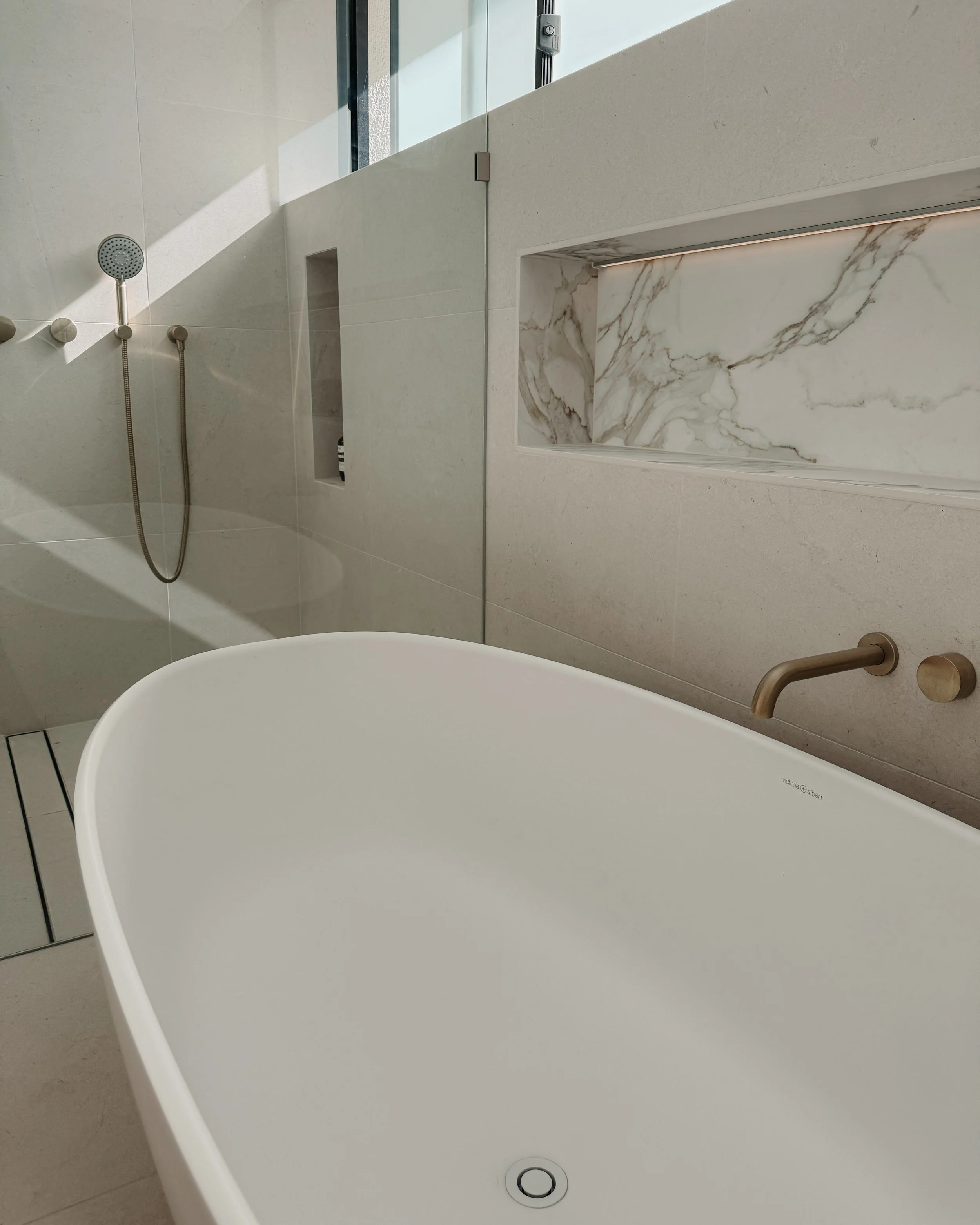 Modern bathroom custom curved vanity, and warm timber tones, fluted timber detail — coastal apartment in Gold Coast designed by TID Studio Sydney