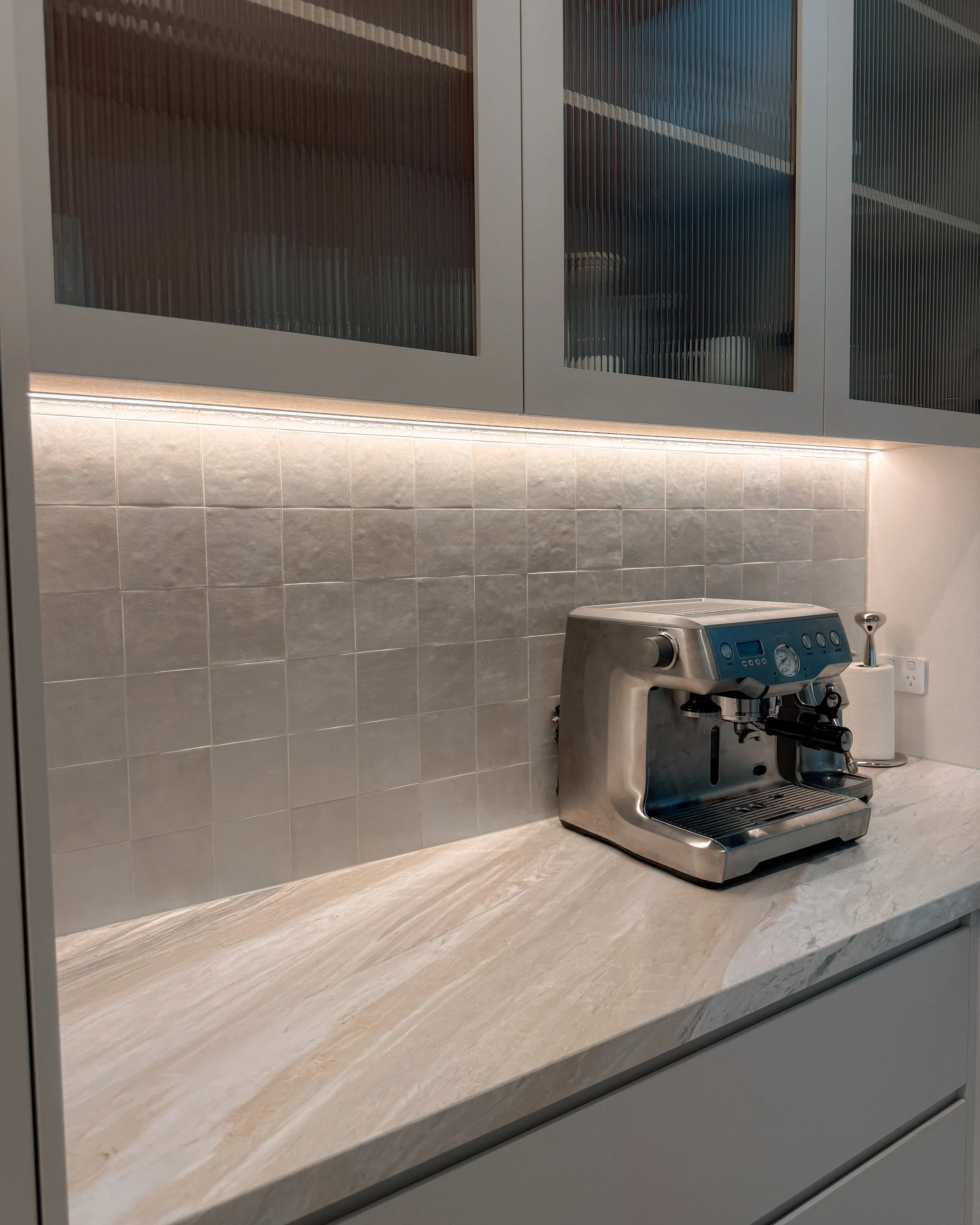 Contemporary soft-curved kitchen with fluted island, light timber cabinetry, and sculptural rangehood in a minimal-luxe Melbourne new-build. Designed by TID Studio, interior design in Sydney