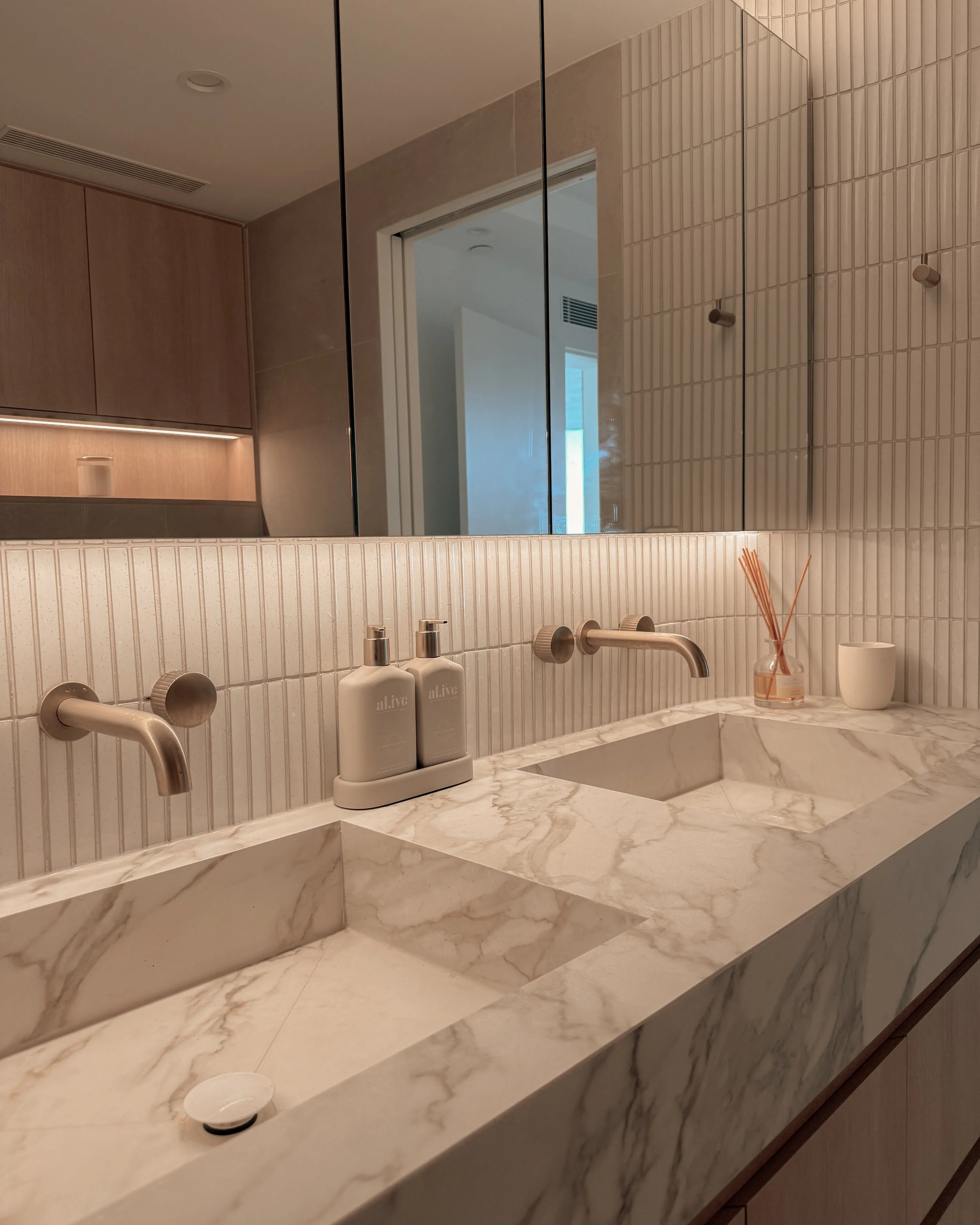 Modern bathroom with stone sink, double vanity, and warm timber tones — coastal apartment in Gold Coast designed by TID Studio Sydney