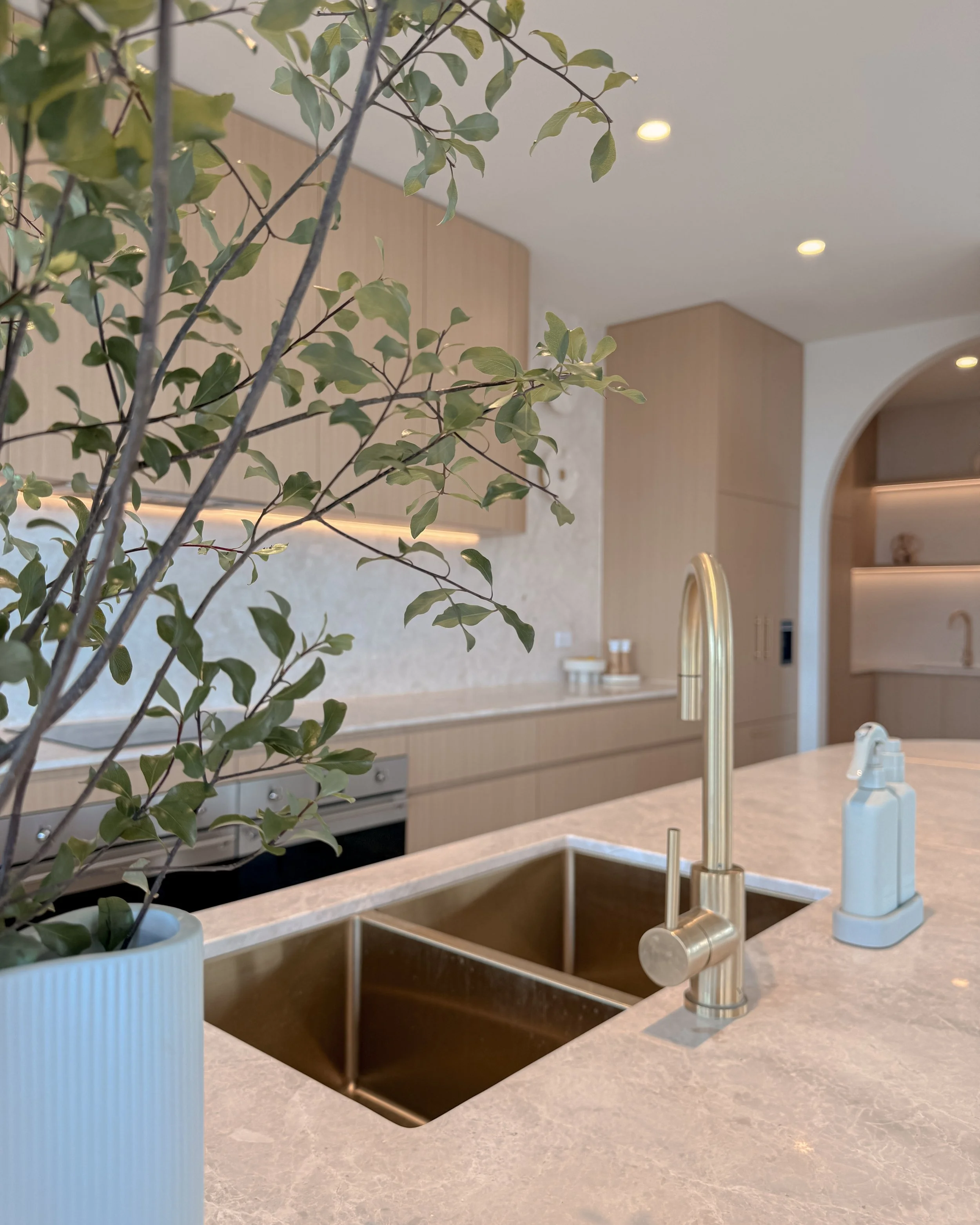 Modern coastal kitchen and pantry designed by TID Studio. Contemporary kitchen with curved cabinetry and fluted stone kitchen island. Sydney interior designer
