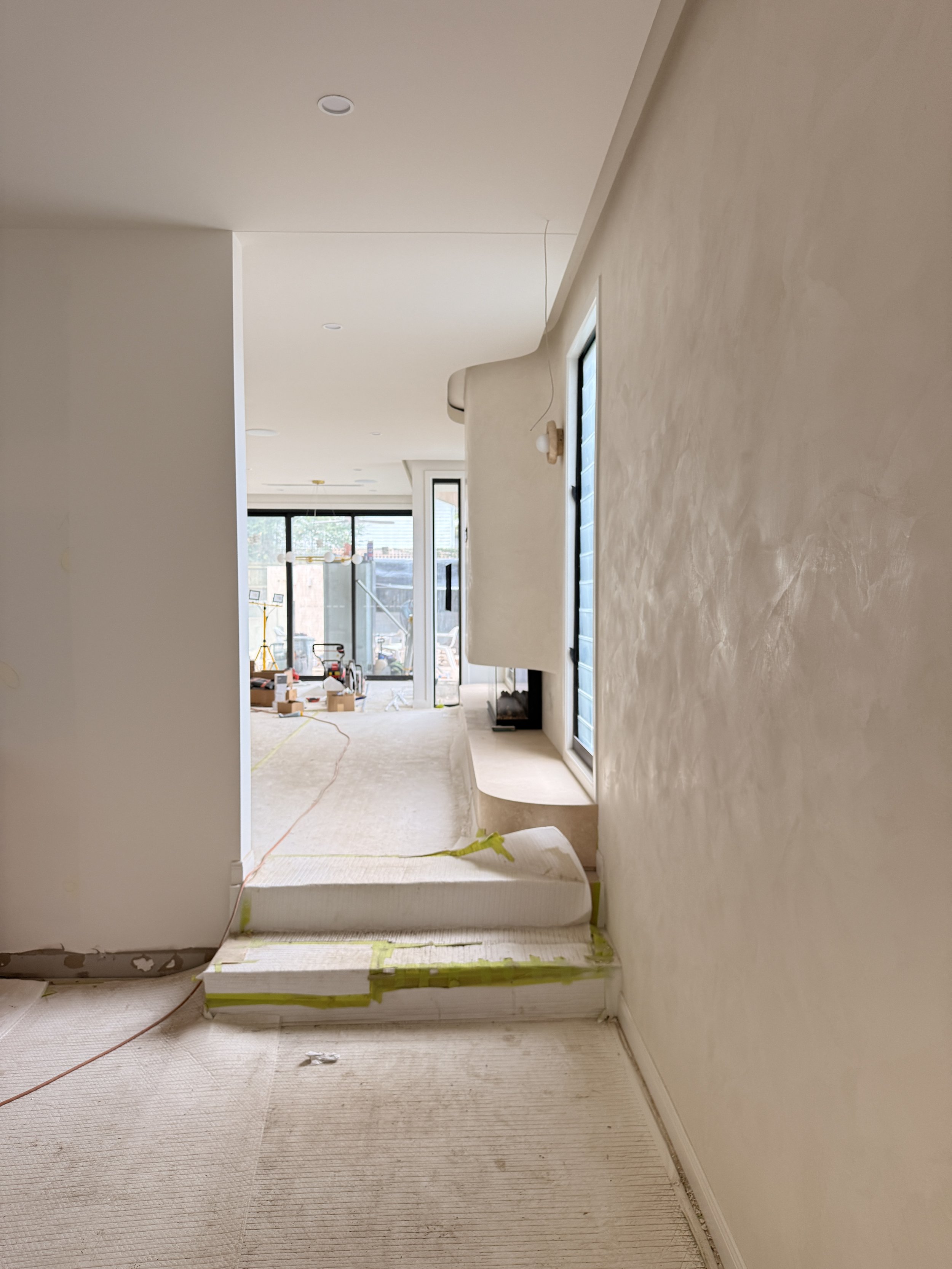 Modern coastal living room with soft plaster walls, light timber flooring and fireplace  — Auriga Residence by TID Studio, interior designer Sydney
