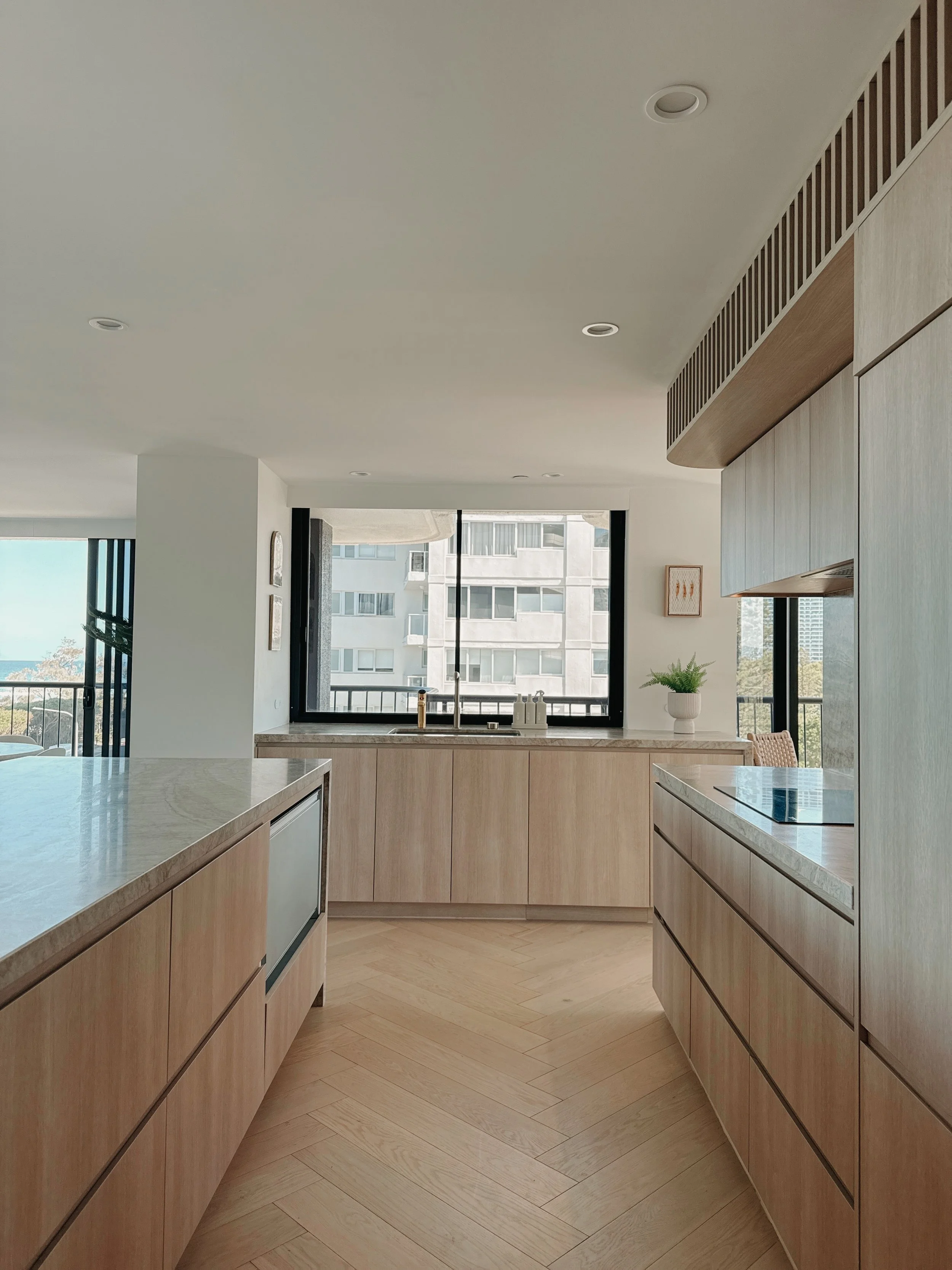 Soft neutral kitchen with ocean views and minimalist joinery by TID Studio