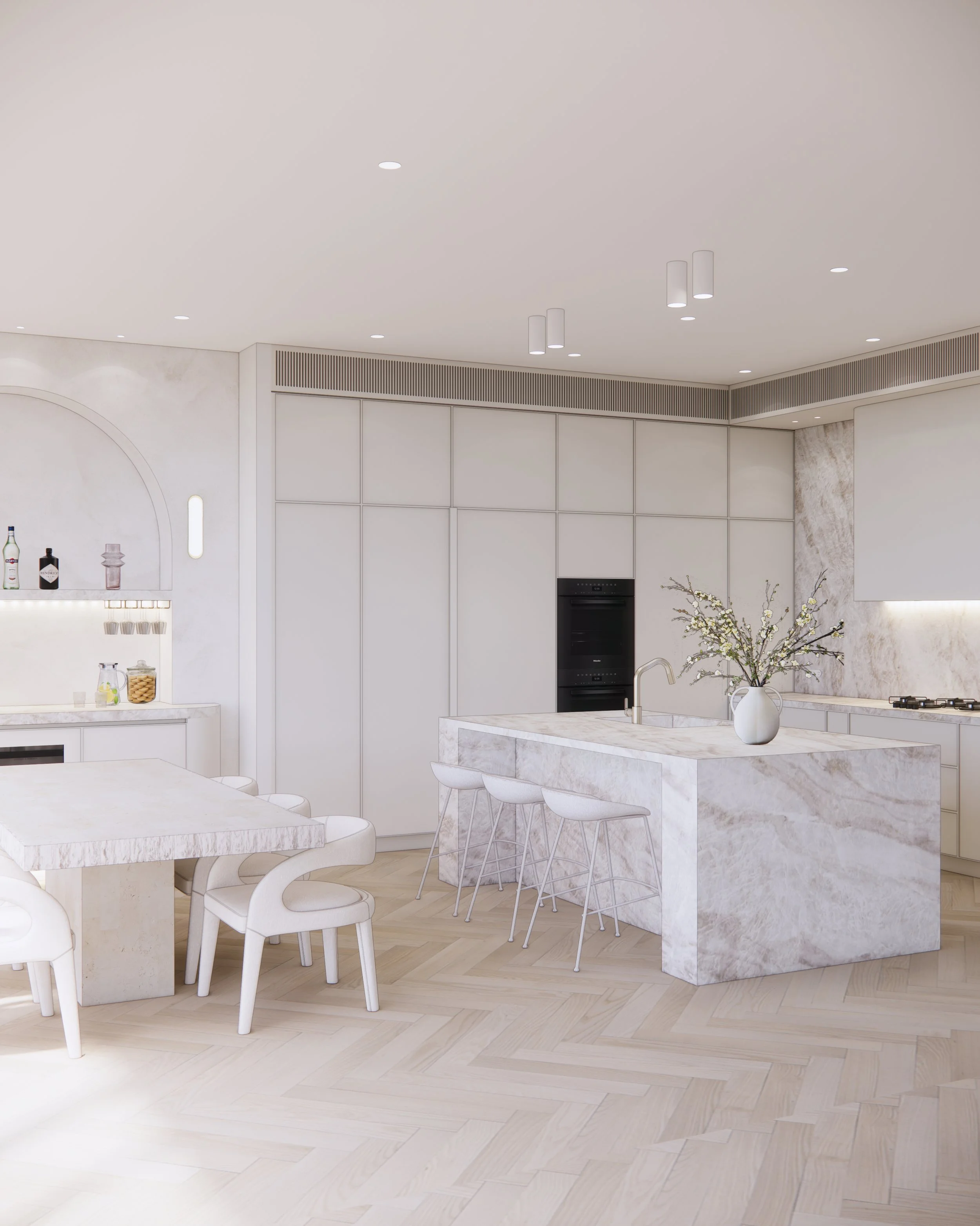 Open-plan kitchen and bar area featuring soft neutral palette and sculptural stone island