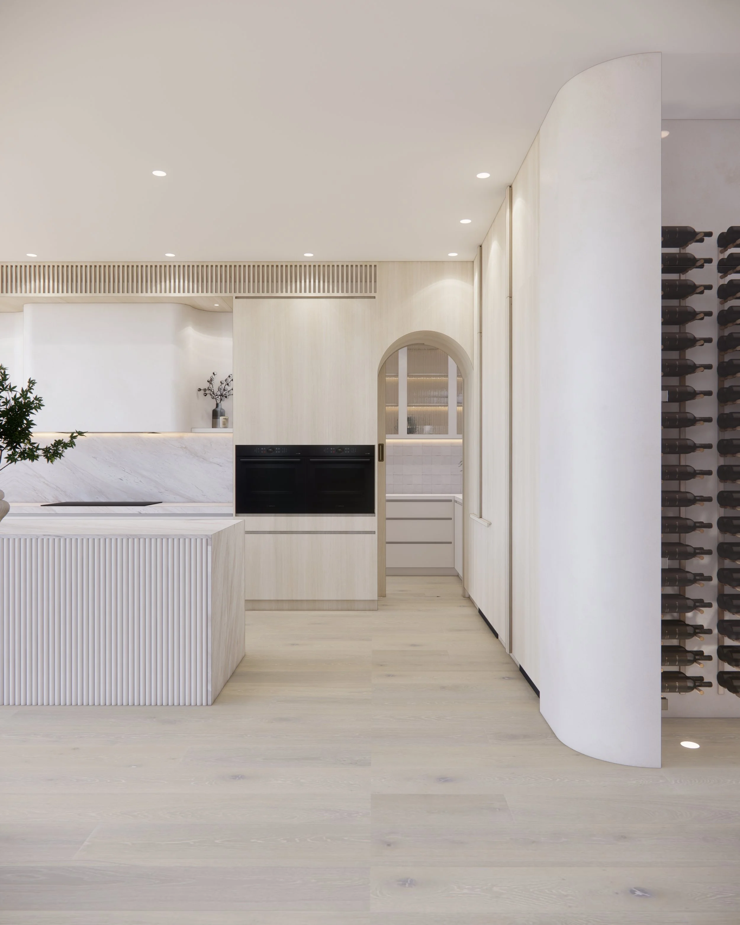 Contemporary soft-curved kitchen with fluted island, light timber cabinetry, and sculptural rangehood in a minimal-luxe Melbourne home.