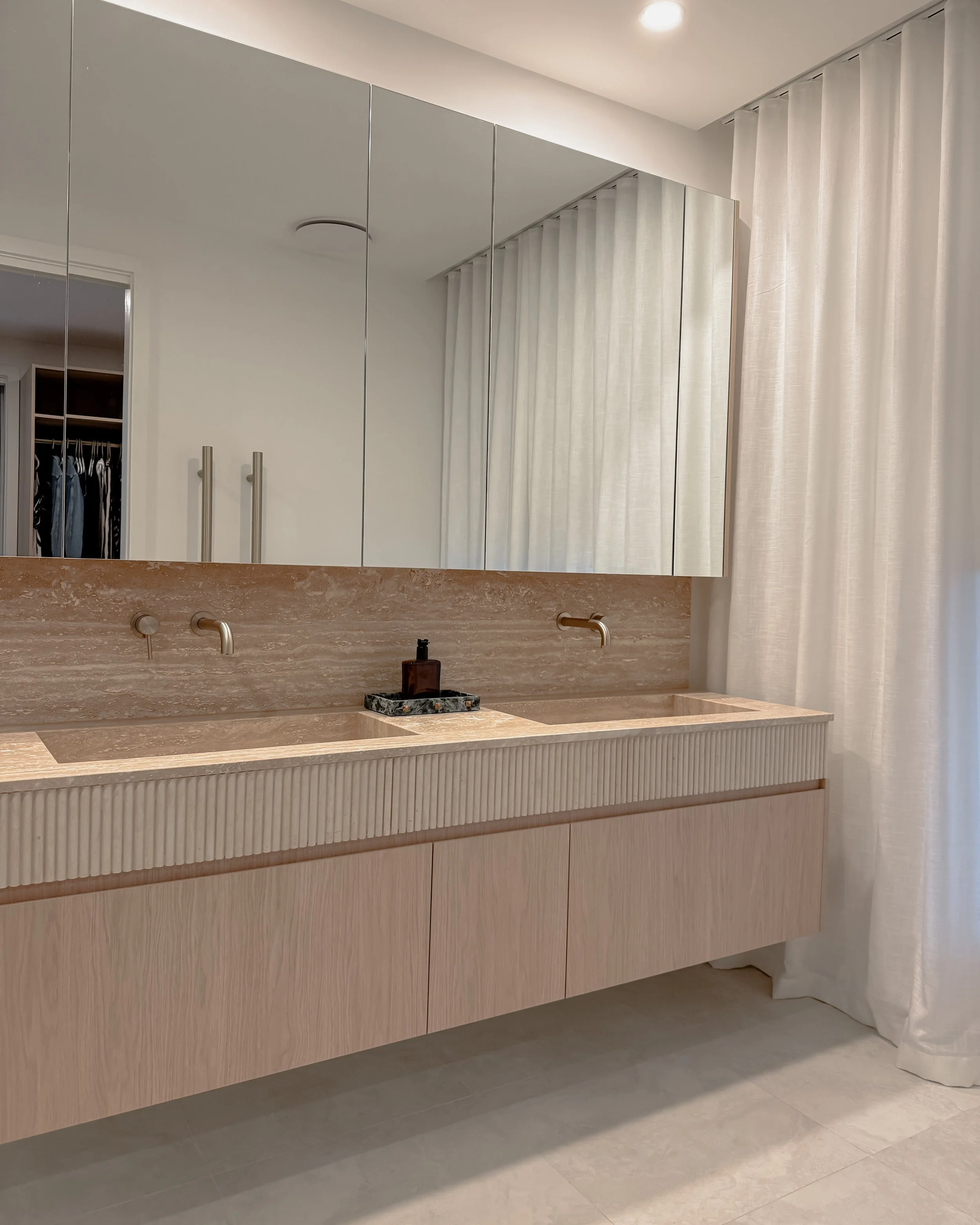 Contemporary Master Ensuite with custom stone sink, fluted travertine, double vanity, double shower in Melbourne new-build. Designed by TID Studio, interior design in Sydney