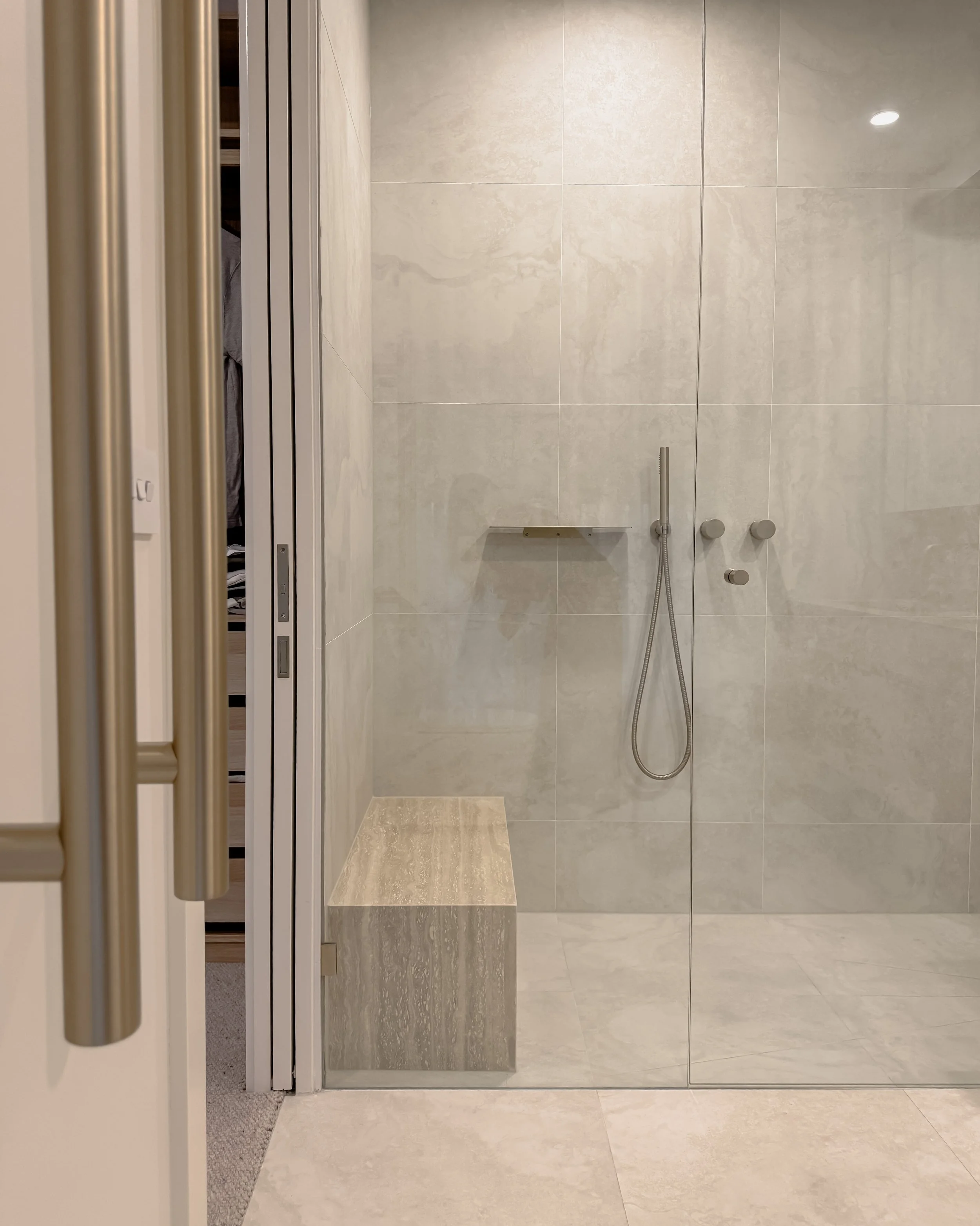 Contemporary Master Ensuite with custom stone sink, fluted travertine, double vanity, double shower in Melbourne new-build. Designed by TID Studio, interior design in Sydney