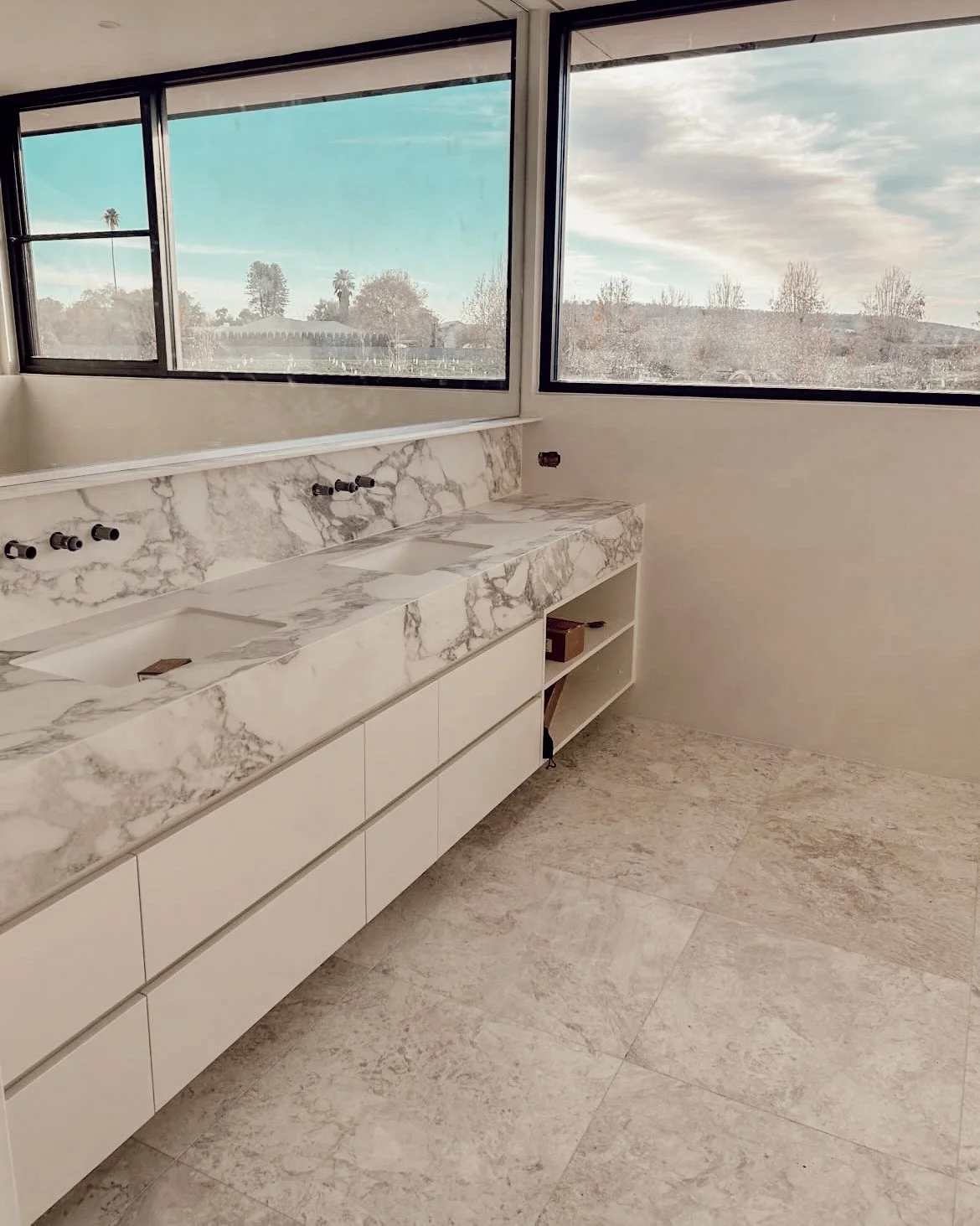A serene, modern bathroom with marble surfaces and soft timber detailing, part of TID Studio’s Sydney renovation