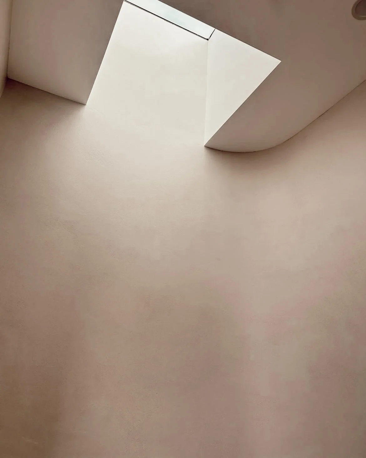 Soft minimal ensuite design in Sydney featuring a curved shower wall, brushed nickel tapware and warm neutral finishes by TID Studio