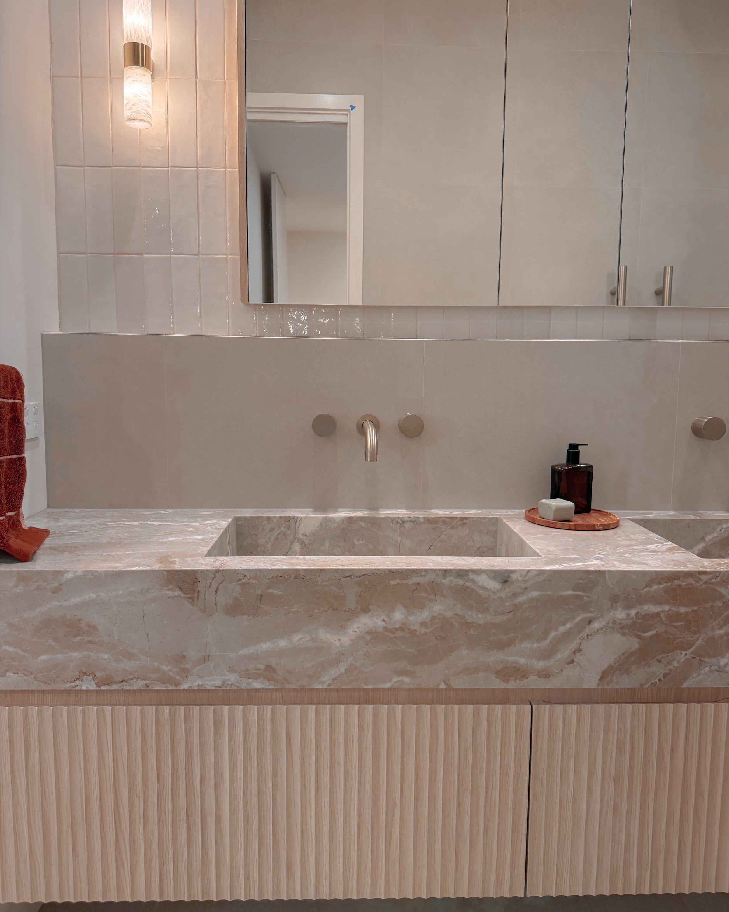 Contemporary bathroom with custom stone sink, fluted cabinets, double vanity in Melbourne new-build. Designed by TID Studio, interior design in Sydney