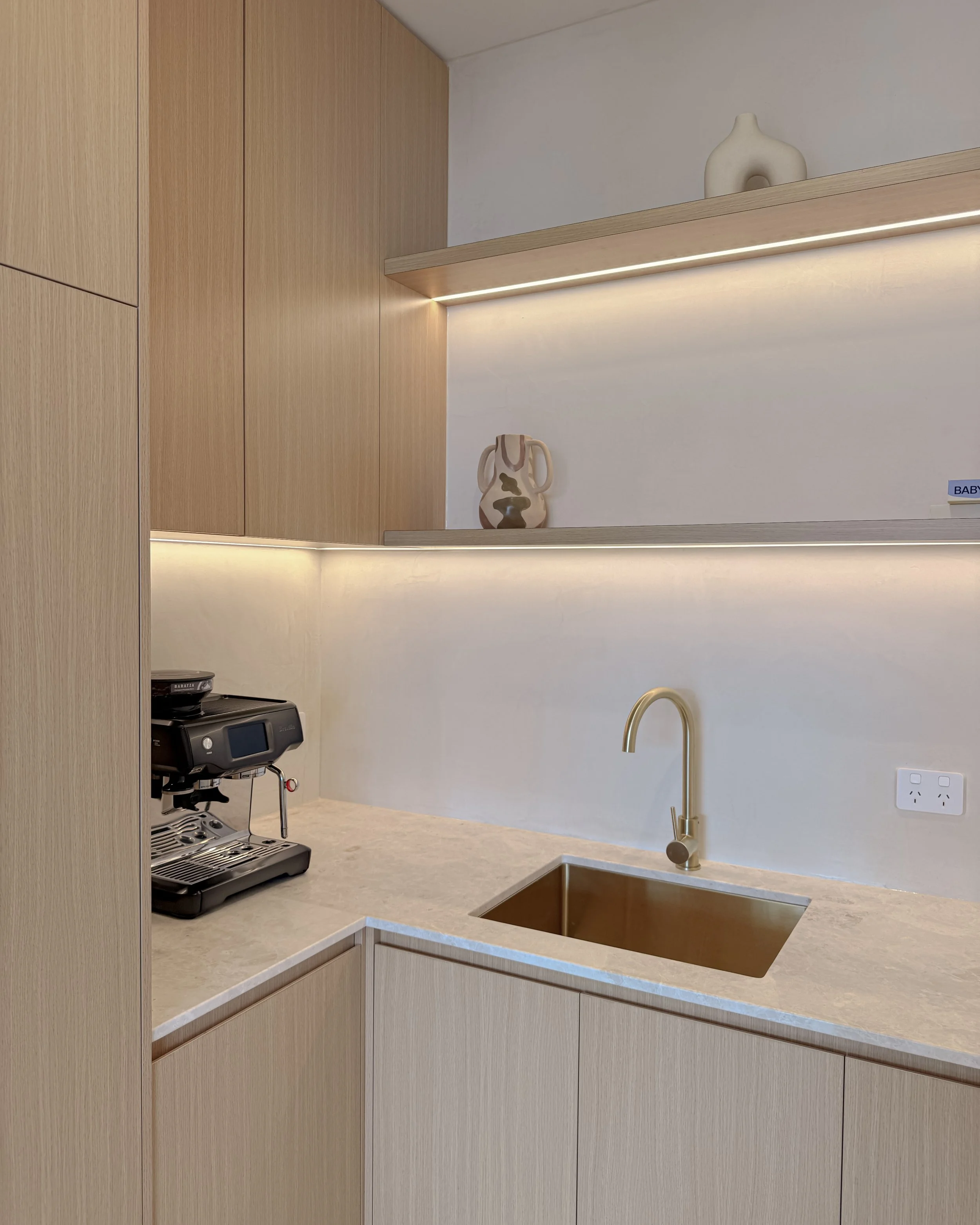 Modern coastal kitchen and pantry designed by TID Studio. Contemporary kitchen with curved cabinetry and fluted stone kitchen island. Sydney interior designer