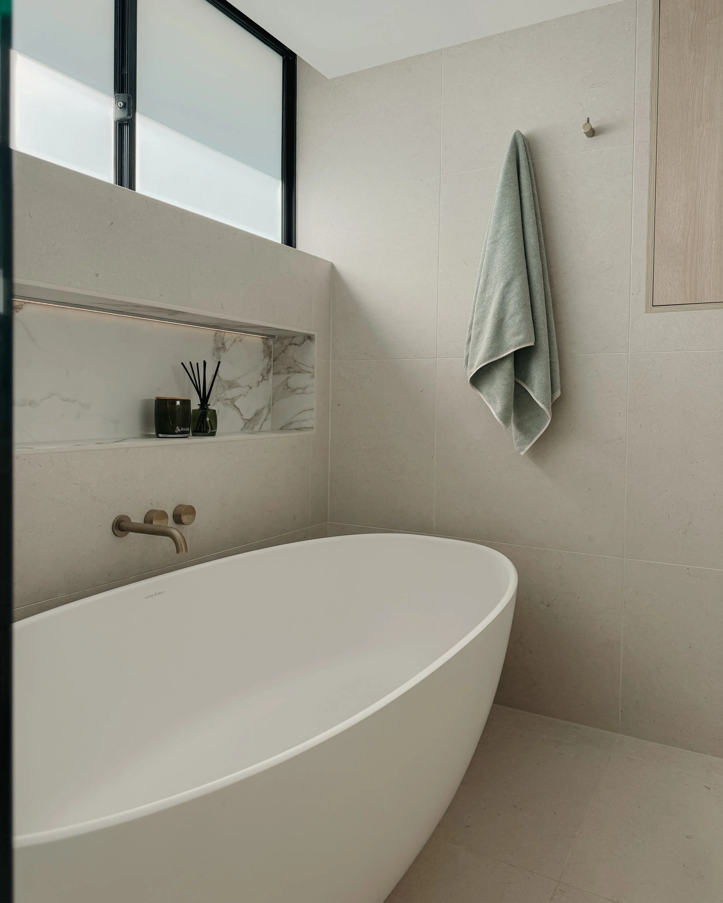 Modern bathroom custom curved vanity, and warm timber tones, fluted timber detail — coastal apartment in Gold Coast designed by TID Studio Sydney