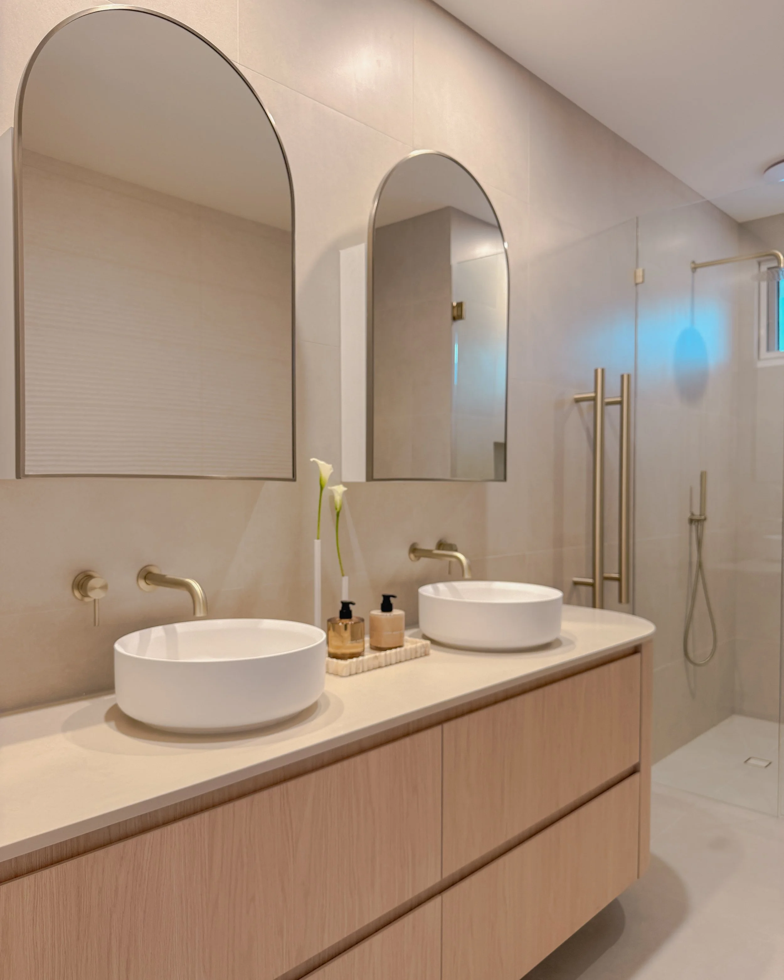 Contemporary bathroom with custom stone sink, fluted travertine, double vanity, double shower in Melbourne new-build. Designed by TID Studio, interior design in Sydney