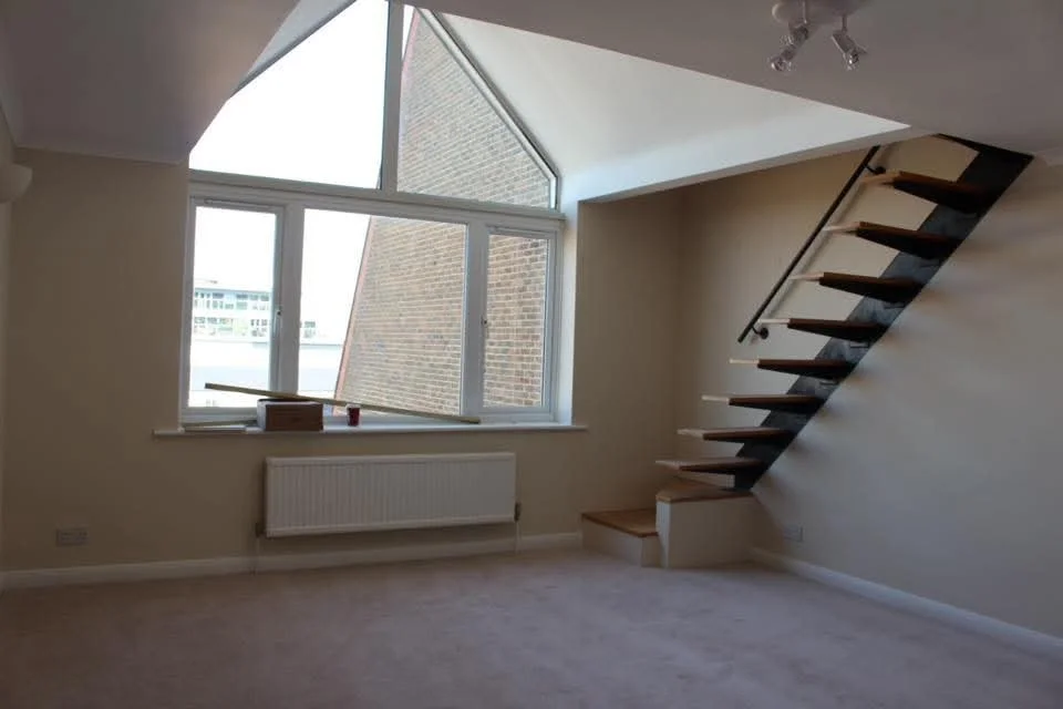Interior painting of living room in split level apartment with nicotine stains, with smooth neutral walls and brilliant white ceiling.
