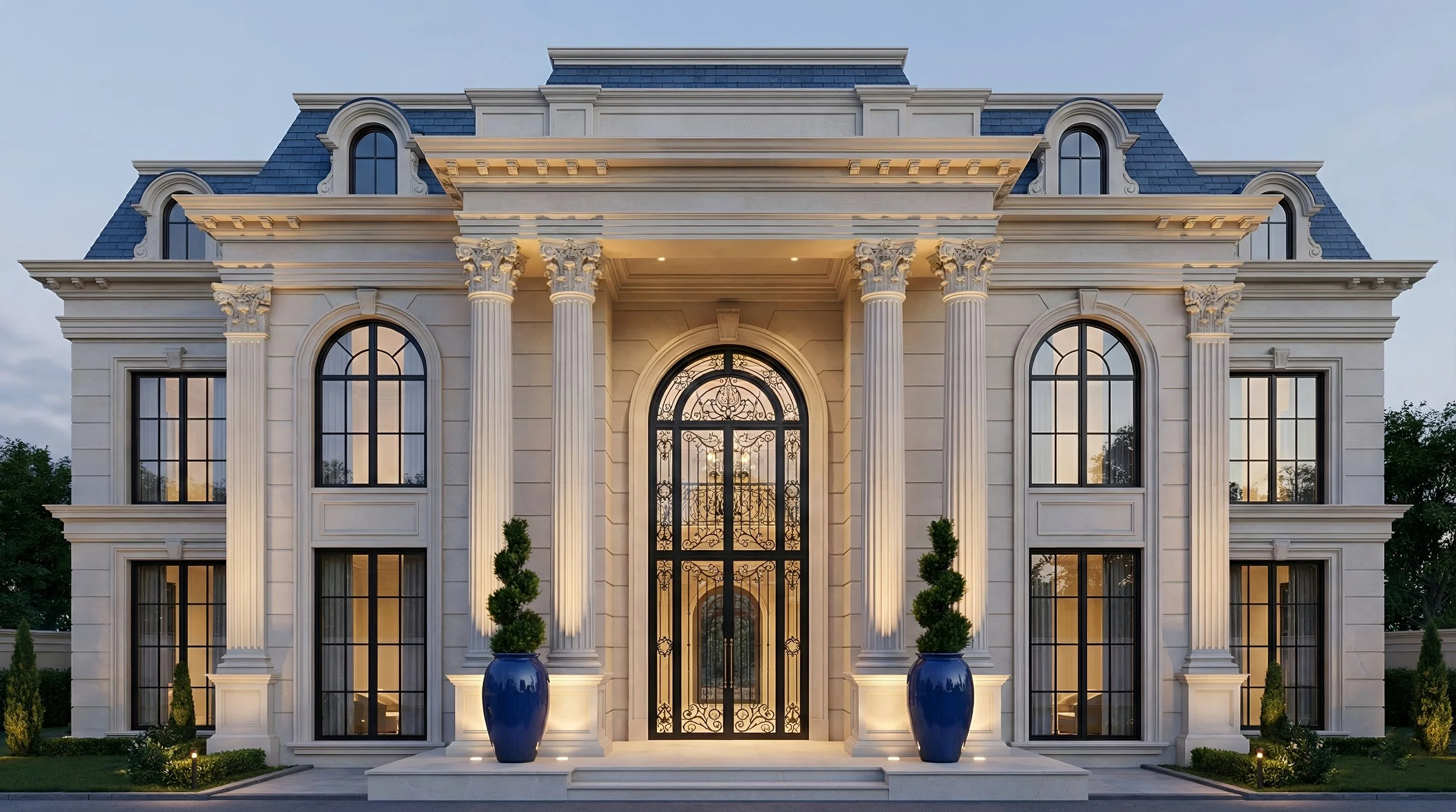 Elegant, large mansion with classical architecture, white stone facade, tall columns, arched windows, ornate black iron gate, and blue planters with green plants beside the entrance.