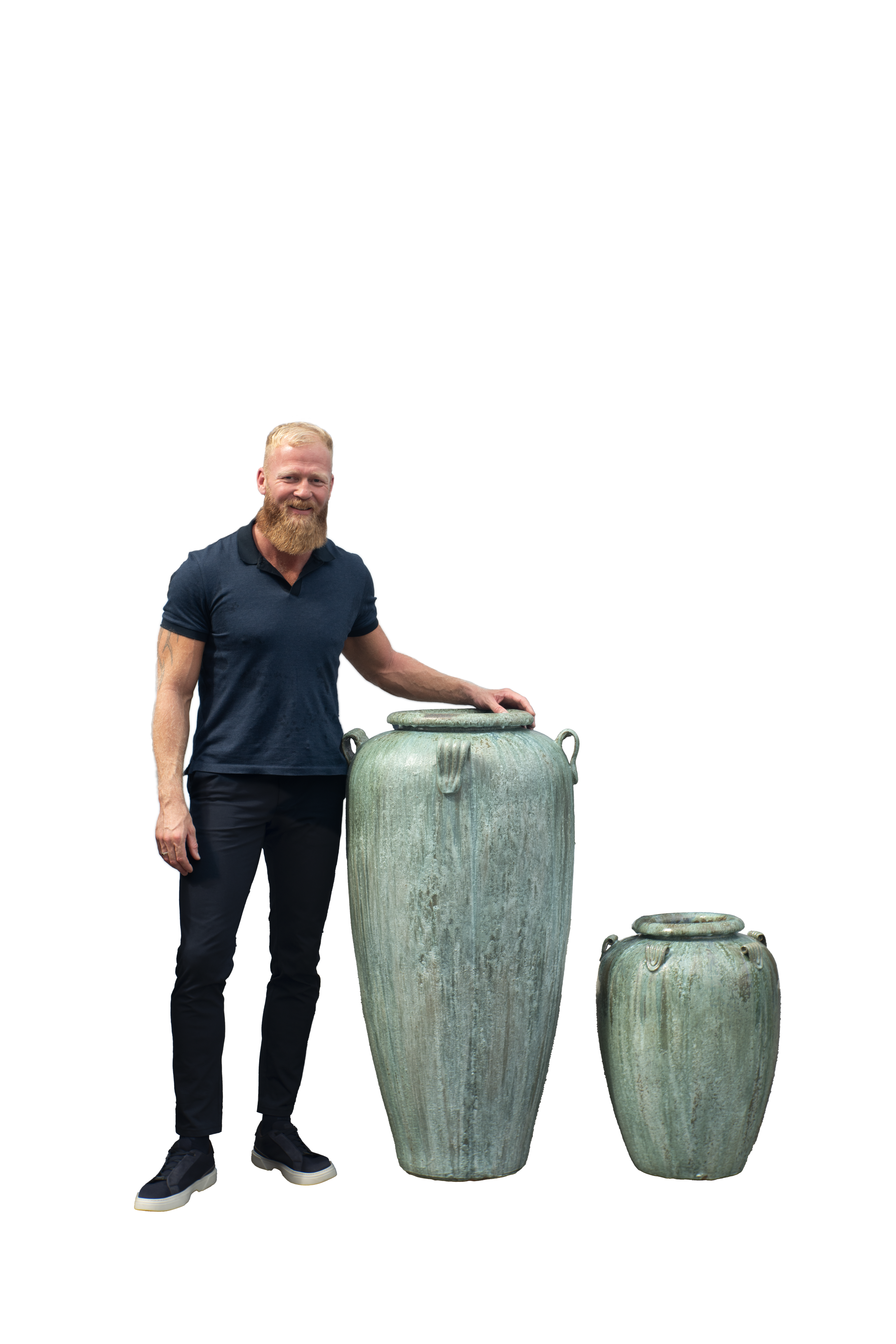 A man with a beard standing next to two large ancient bronze or copper urns or vases, one taller than the other.