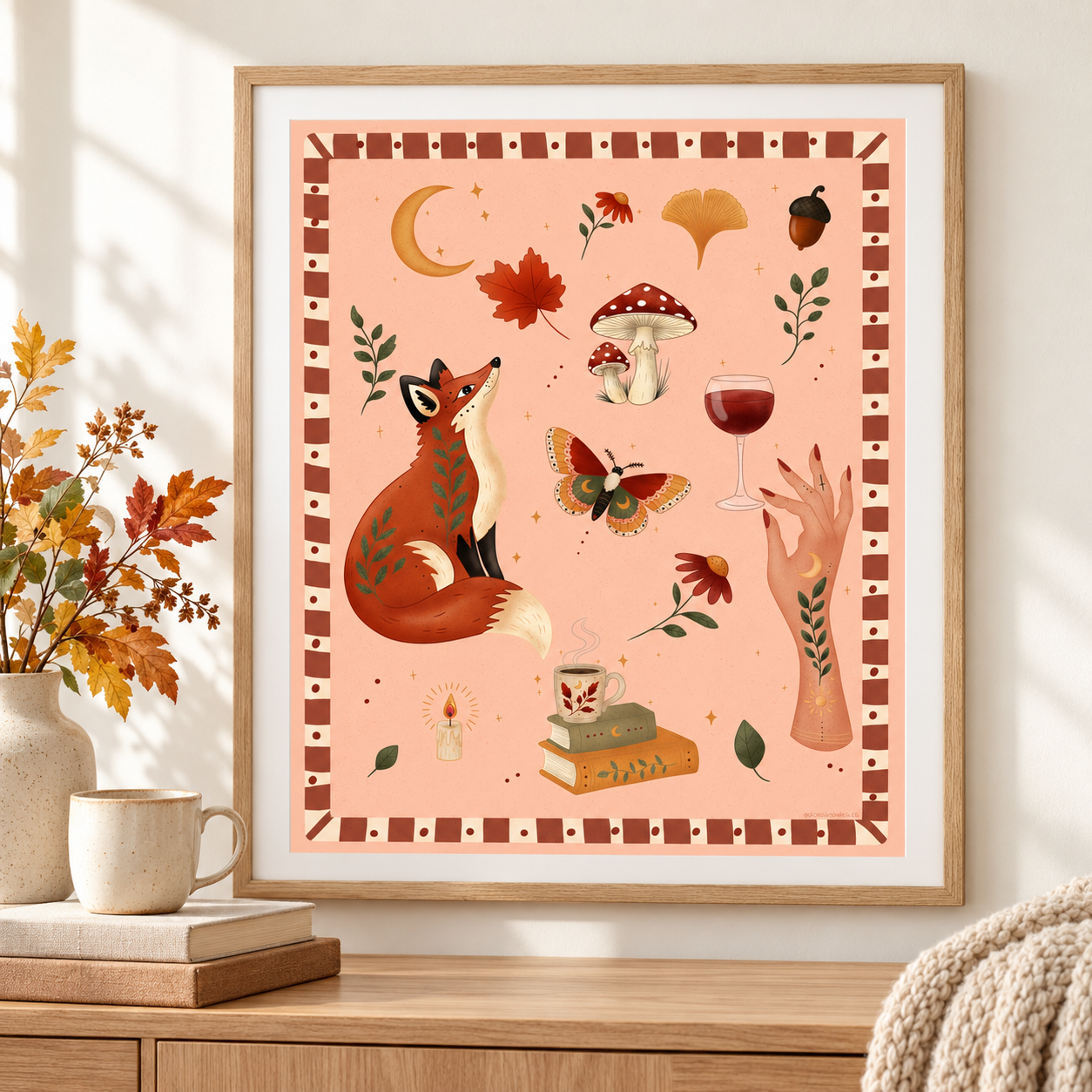 Cozy Autumn art print in a light wooden frame beside a fireplace, with warm autumn colours.