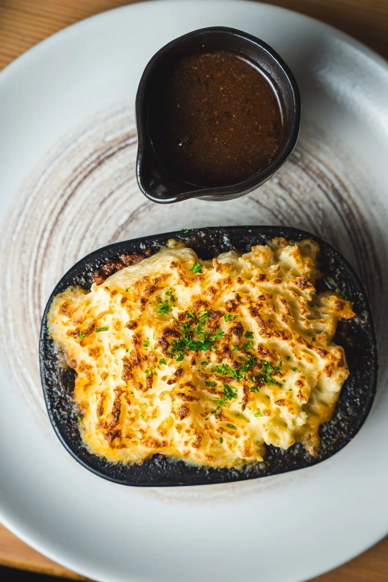 Close-up of a plated meal with a roast beef sandwich, French fries, and a side salad with lettuce and tomato.