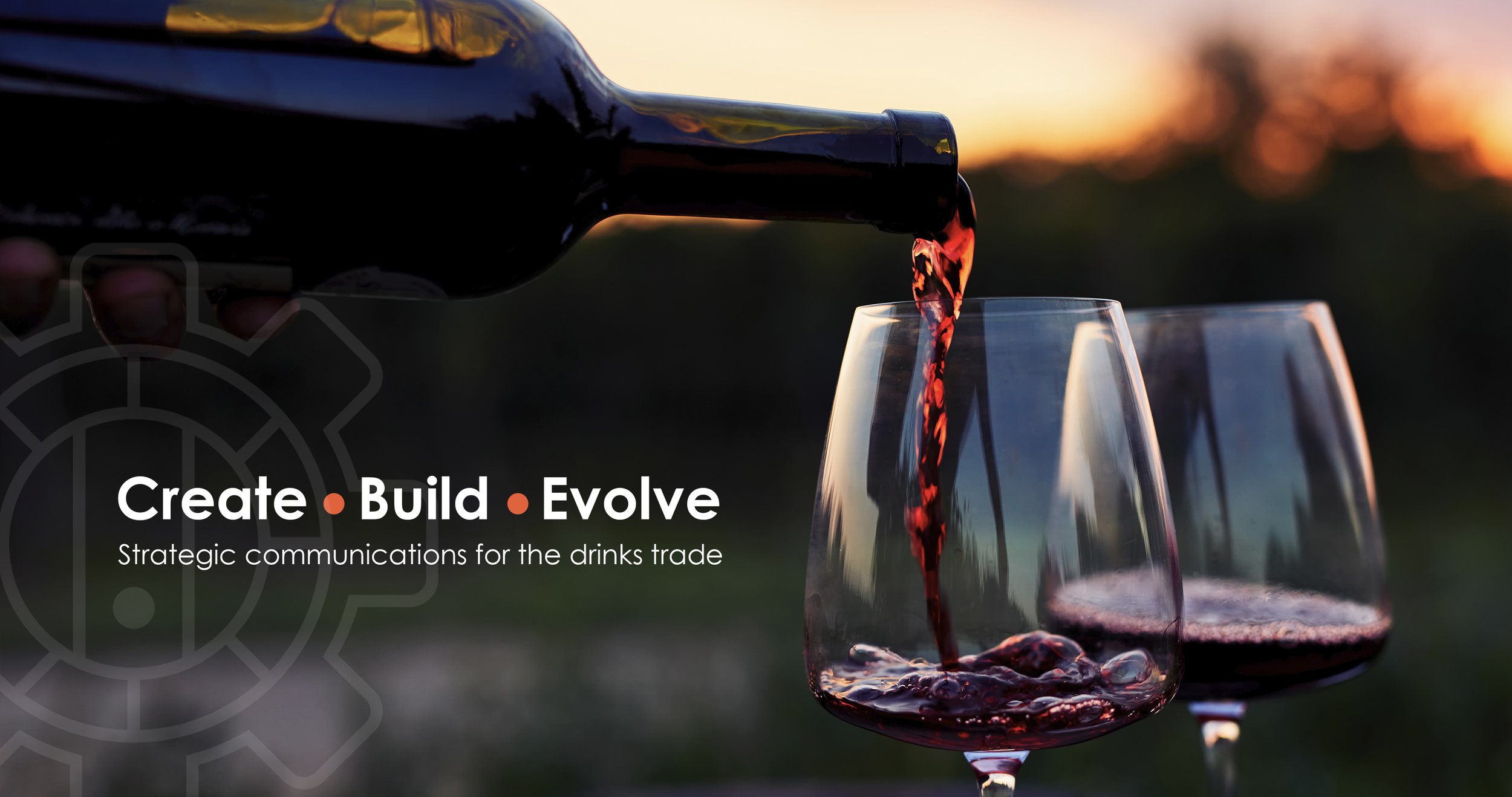 Red wine is poured into a glass, with a sunset in the background and three glasses of wine on a table. Text overlay reads: 'Create Build Evolve. Strategic communications for the drinks trade.'