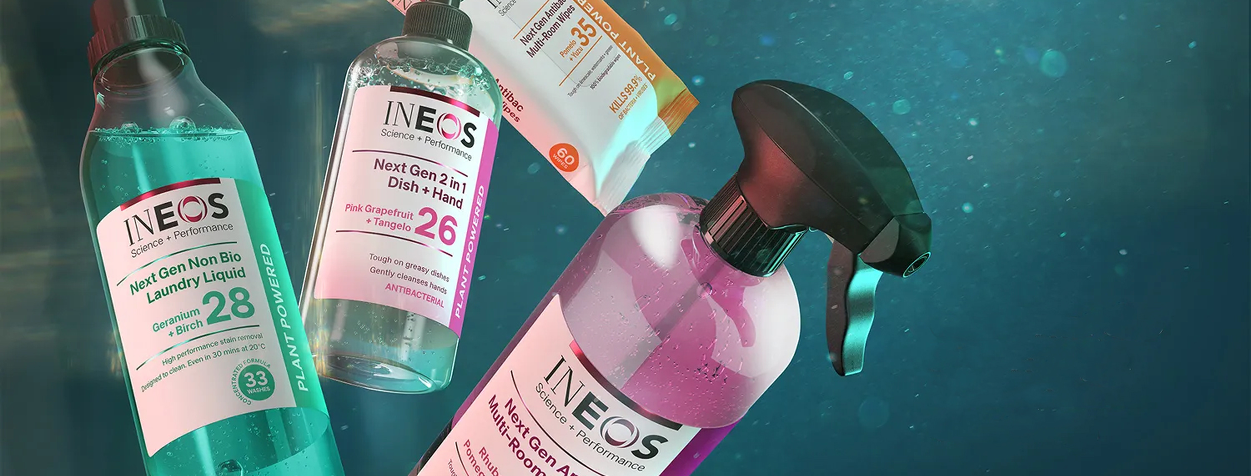 Assorted cleaning products underwater, including bottles of INEOS laundry liquid, dish and hand soap, and multi-room spray.
