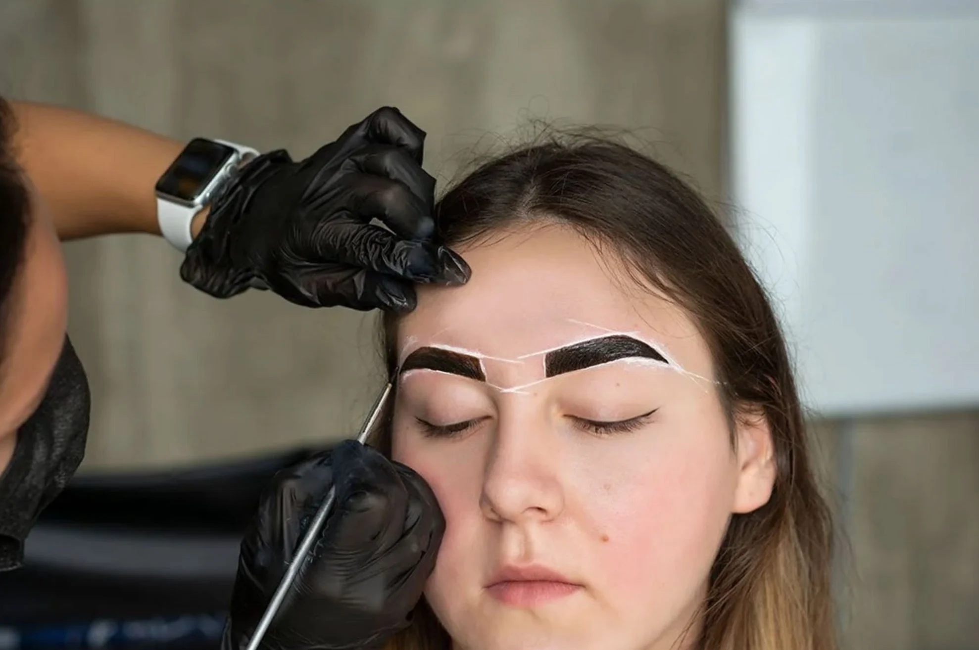 Woman receiving henna brow treatment