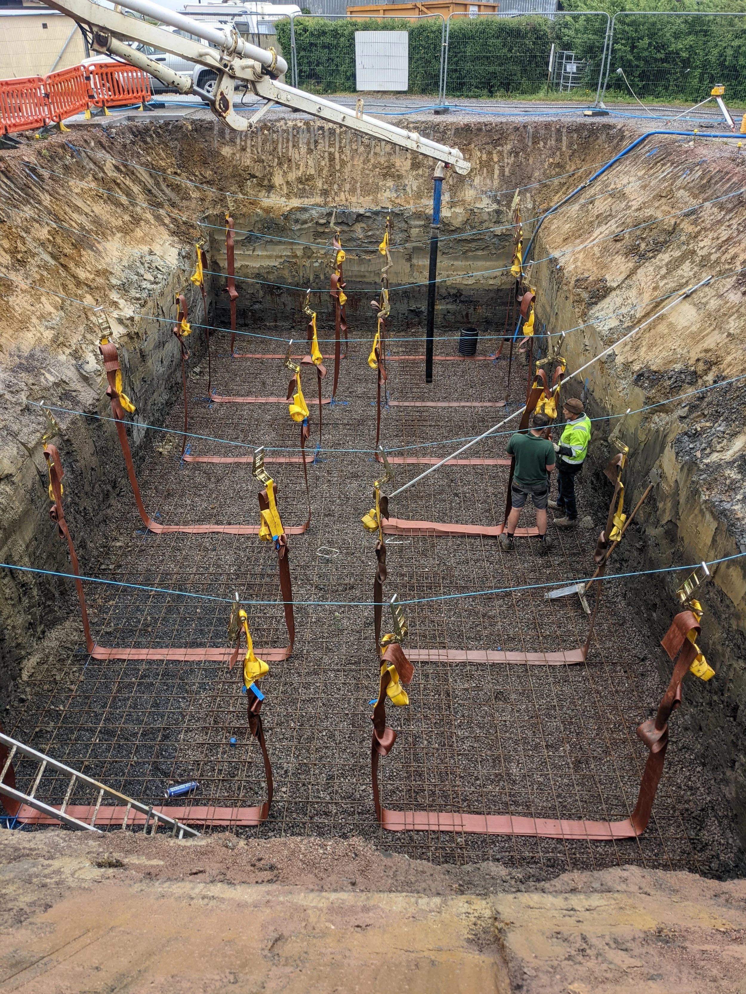 Reinforced slab with holding down straps for tanks