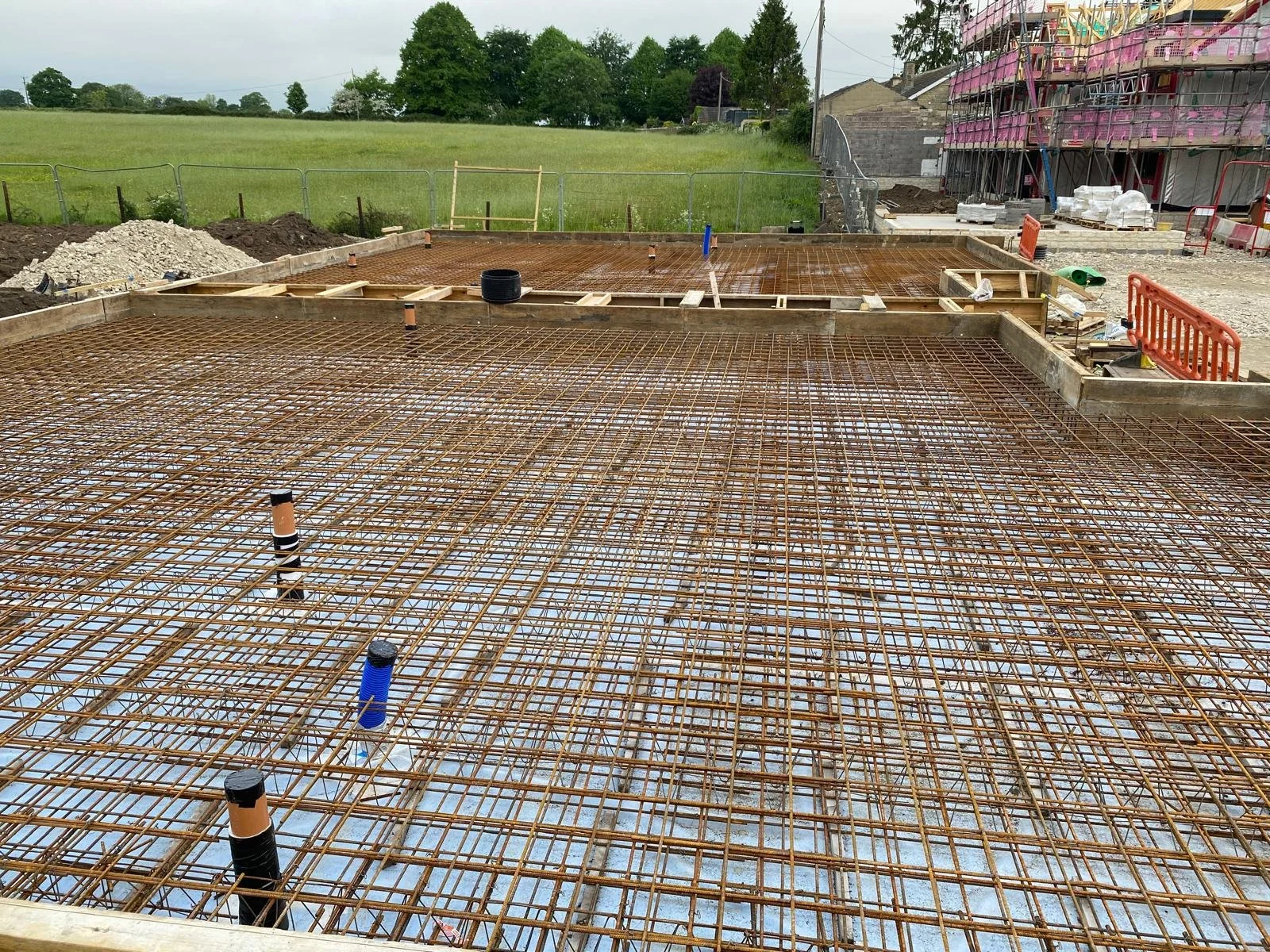 Reinforced raft foundation for two houses