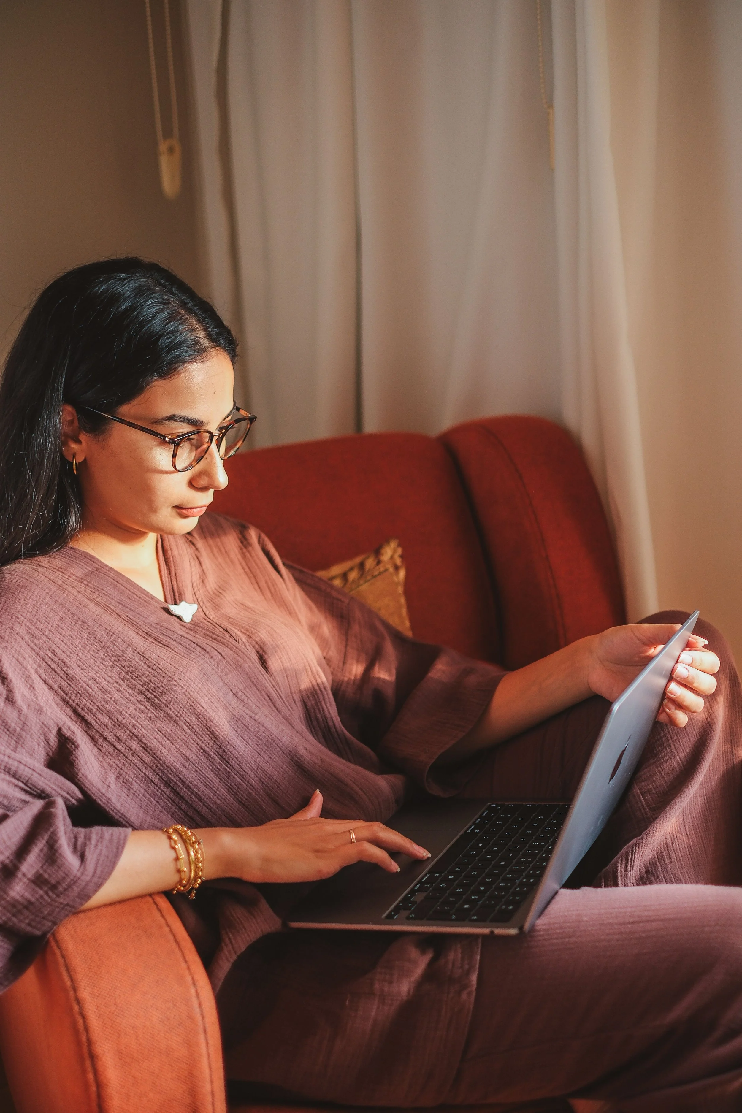 Woman using a laptop on a sofa