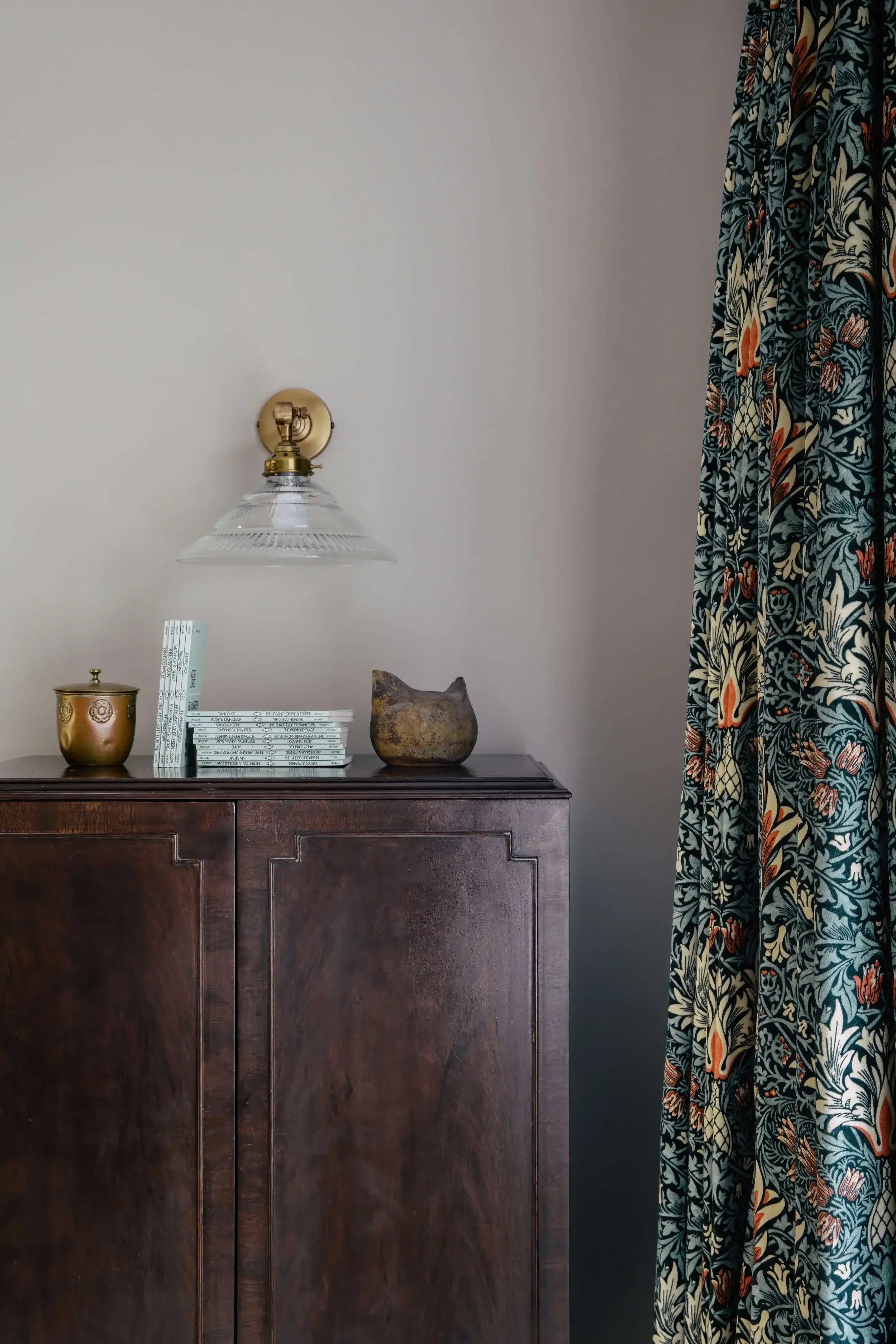 Interior view of a modern training club lounge with a large TV screen, a row of chairs, a small table, and a coffee machine area, decorated with wood accents and natural light.