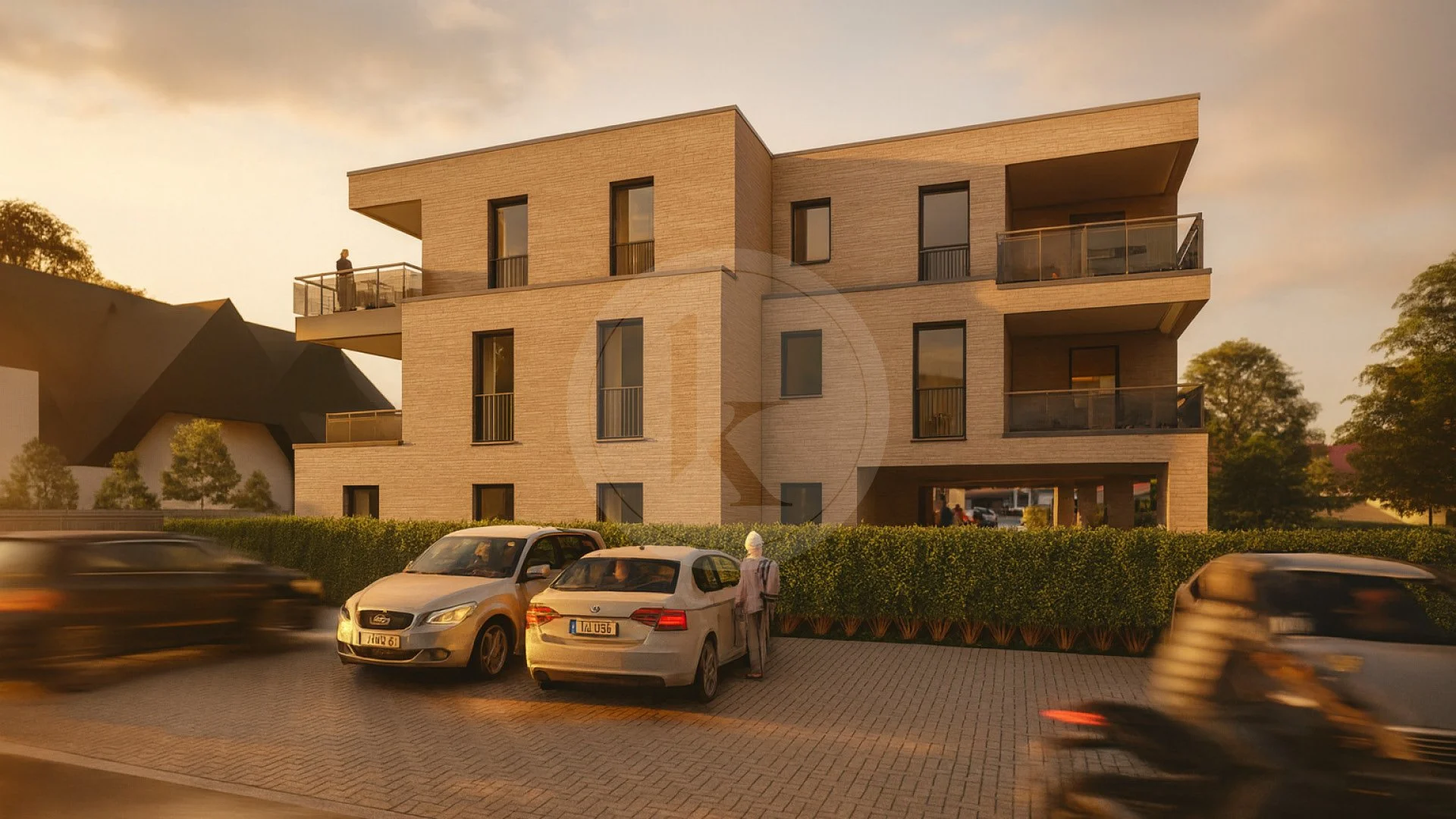 Modernes vierstöckiges Wohngebäude bei Sonnenuntergang mit Balkonen, parkenden Autos im Vordergrund und Bäumen im Hintergrund.