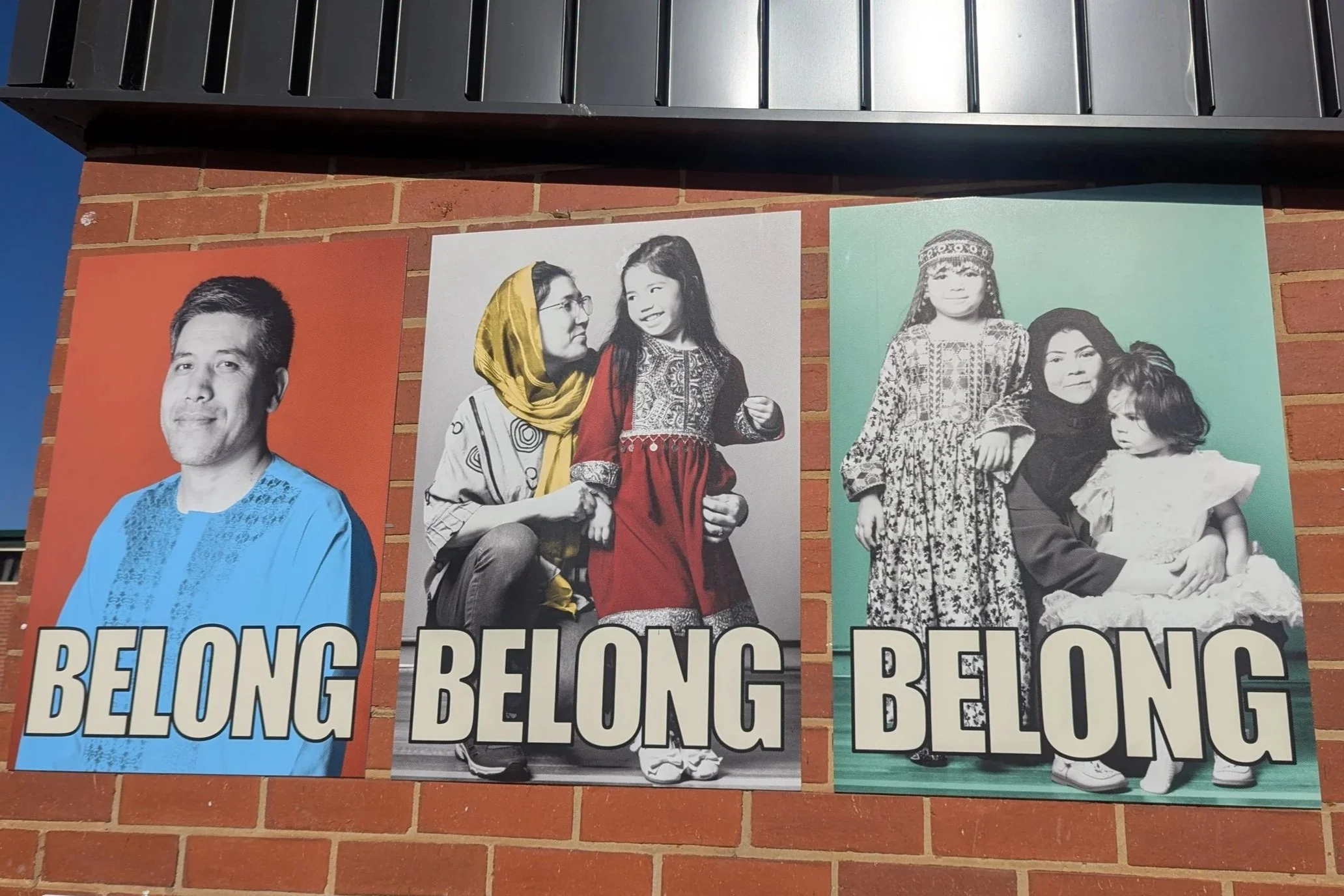 Three designed posters of people in cultural dress with the word BELONG at the bottom