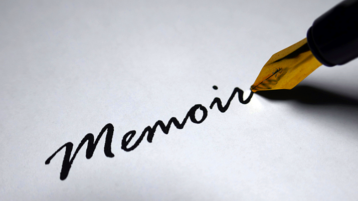 Close-up of a fountain pen writing the word 'Memoir' on paper.
